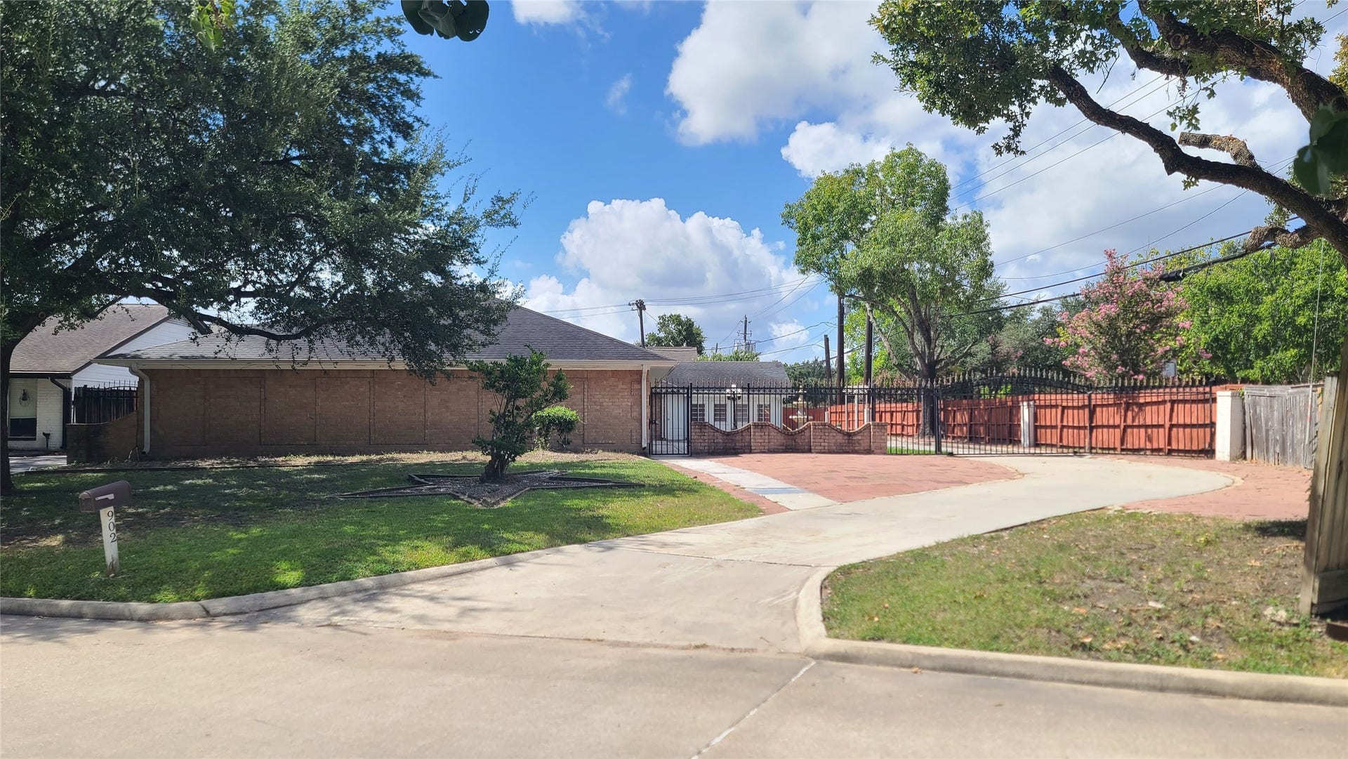 902 Ashford Parkway, Houston, TX 77077 Experience elegance and privacy with this beautiful home, featuring a long driveway and a stately wrought iron gate.
