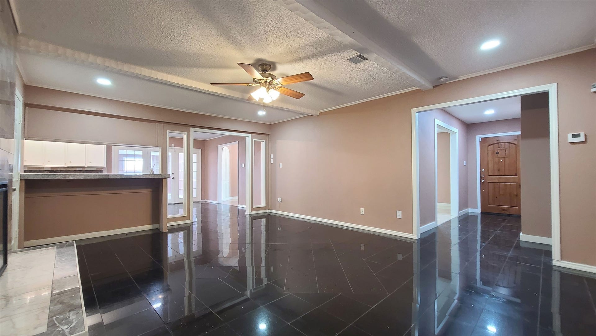 902 Ashford Parkway, Houston, TX 77077 Step into an inviting family room where elegant built-in bookshelves and a cozy seating area create a perfect blend of warmth and sophistication, seamlessly guiding you toward the welcoming entrance.