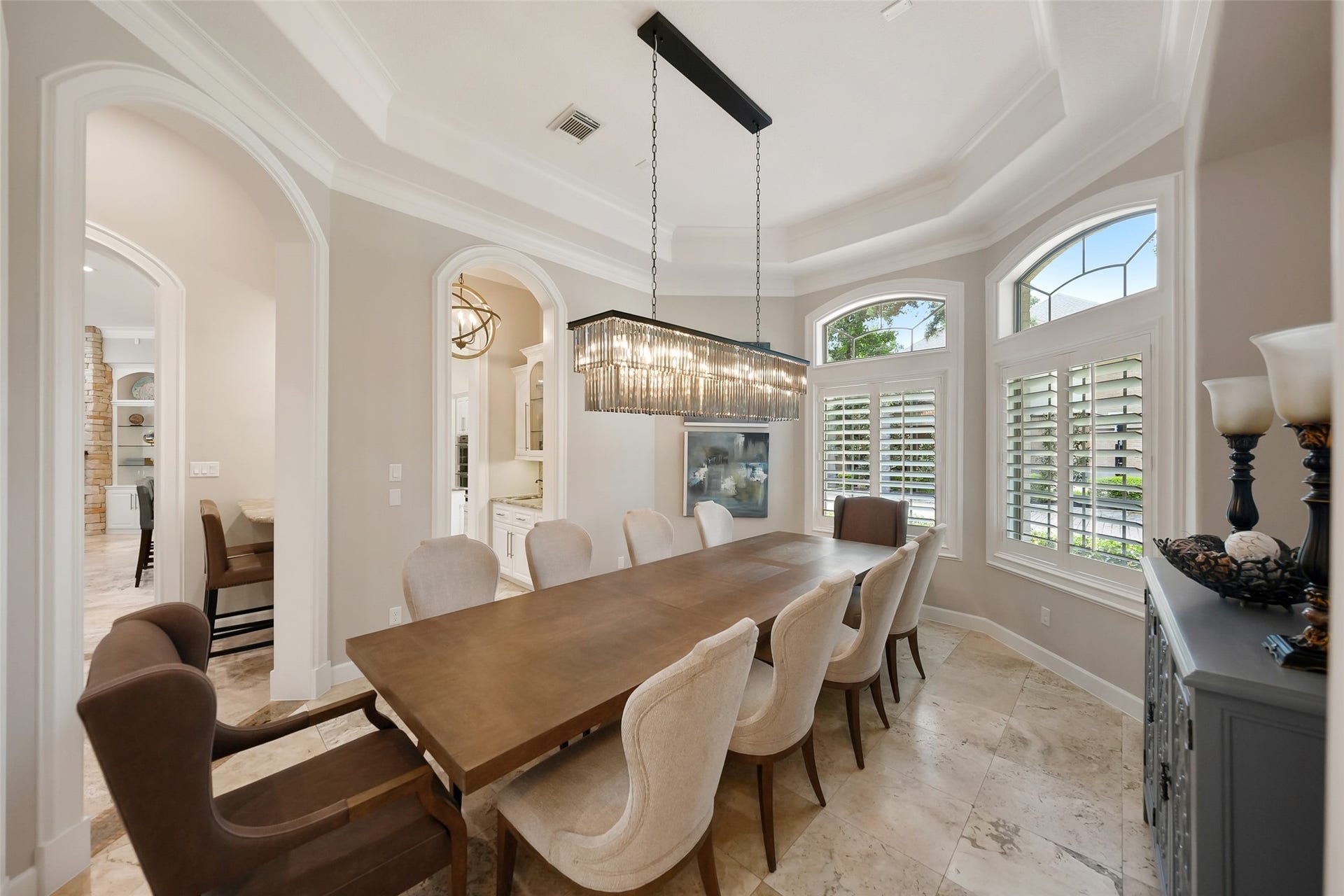 19 Harmony Links Place, The Woodlands, TX 77382 The tray ceiling accentuates the custom dining room's custom lighting. The home's open floorplan flows from room to room. A butler's pantry provides convenient access to the chef's kitchen.