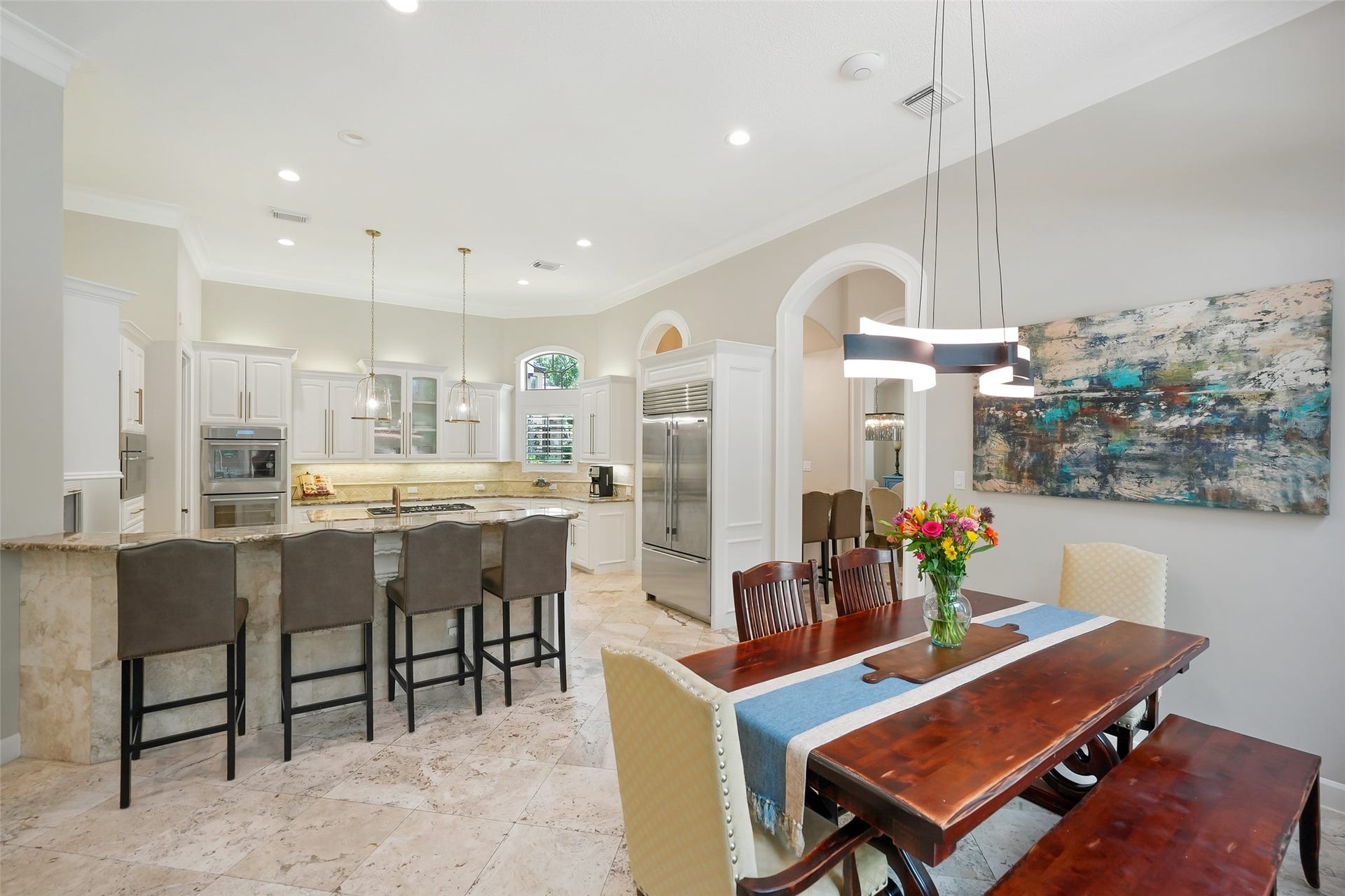 19 Harmony Links Place, The Woodlands, TX 77382 The openness of the thoughtfully designed floor plan is evident in this photo, where seamless connections between the dining room, breakfast room, kitchen, and family room create an effortless flow for both everyday living and entertaining. Each space naturally transitions into the next, enhancing the home's bright, expansive feel while keeping everything connected!