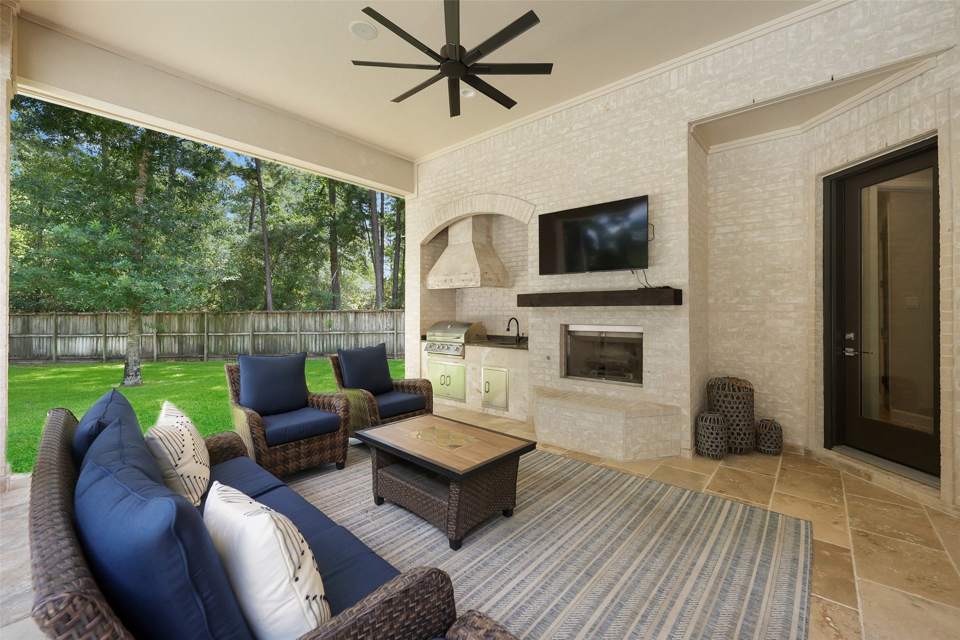 19 Harmony Links Place, The Woodlands, TX 77382 Designed for year-round enjoyment, the spacious outdoor patio is a true extension of the home. Featuring a cozy fireplace, outdoor kitchen with new grill, and a mosquito misting system, this inviting space is perfect for relaxing evenings or hosting guests while enjoying the outdoors in comfort and style.