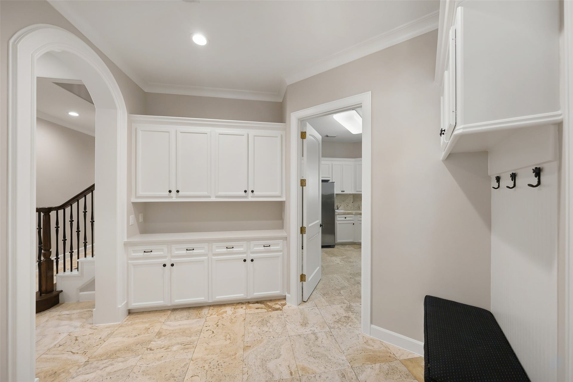 19 Harmony Links Place, The Woodlands, TX 77382 As you enter the home from the garage, the mudroom offers a thoughtfully designed transition space! It features cabinet space for additional storage, offering a practical organized entryway to keep your belongings neatly tucked away! The oversized three car garage is spacious, freshly painted and finished with an epoxy floor coating (2026)!