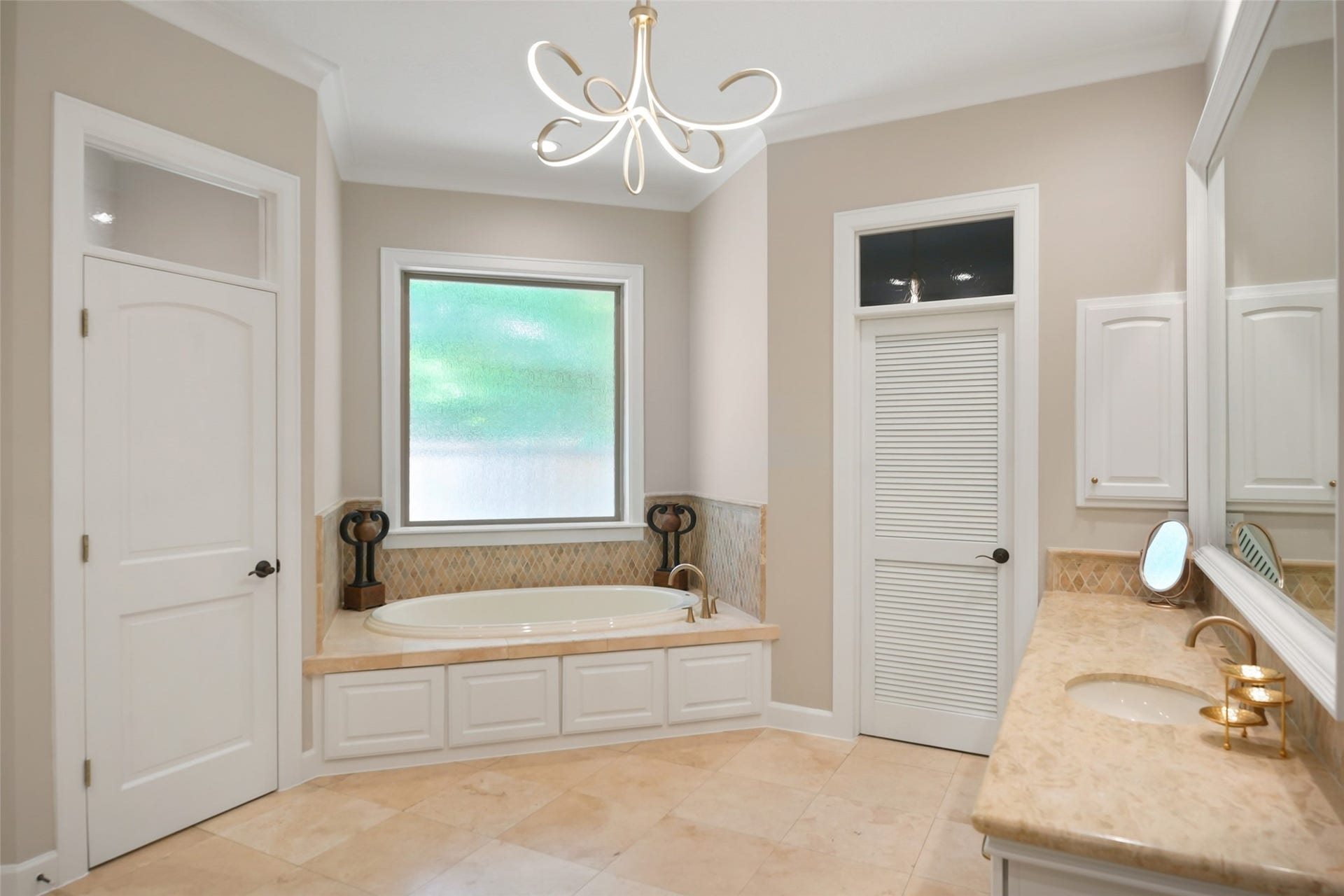 19 Harmony Links Place, The Woodlands, TX 77382 The primary en-suite bath is spacious and tasteful. A deep tub is nestled under the opaque window which floods the space in natural light while maintaining privacy. The primary suite enjoys two primary closets!