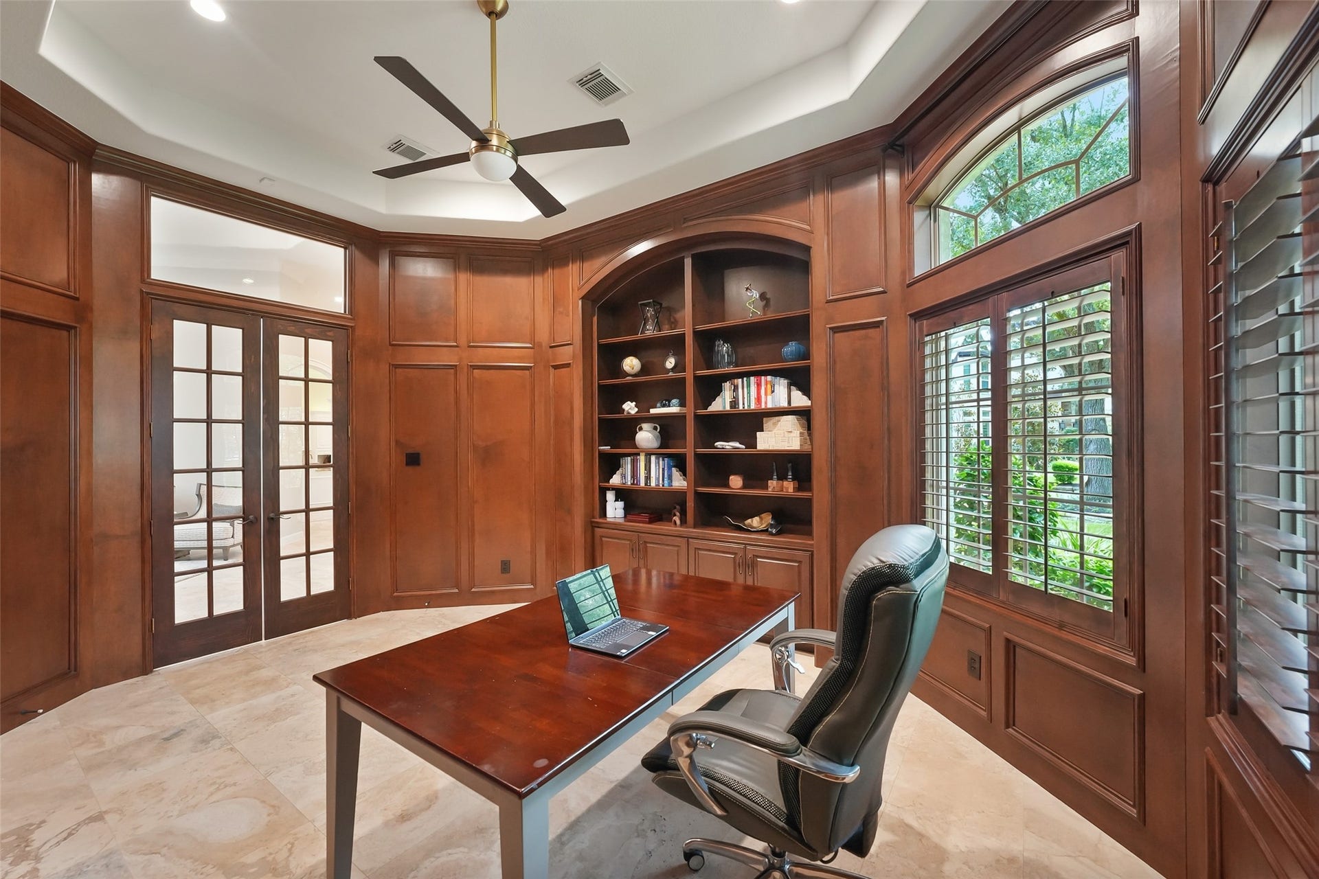 19 Harmony Links Place, The Woodlands, TX 77382 Just beyond the formal entry, French doors lead to the private library. With its built-in bookcases and remarkable millwork, this space offers both abundant storage and a perfect setting for a home office.