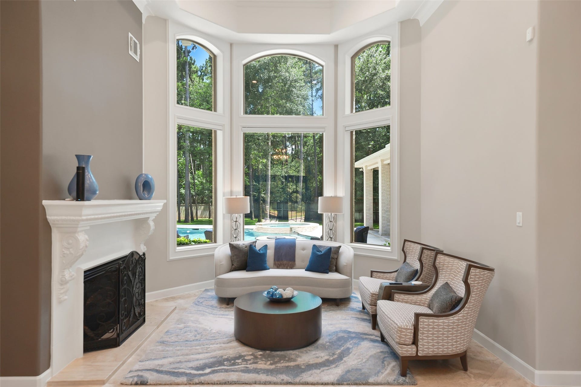19 Harmony Links Place, The Woodlands, TX 77382 The formal living room features a panoramic view of the outdoor pool and spa. Illuminated by large windows and transoms, this is the perfect conversation space.