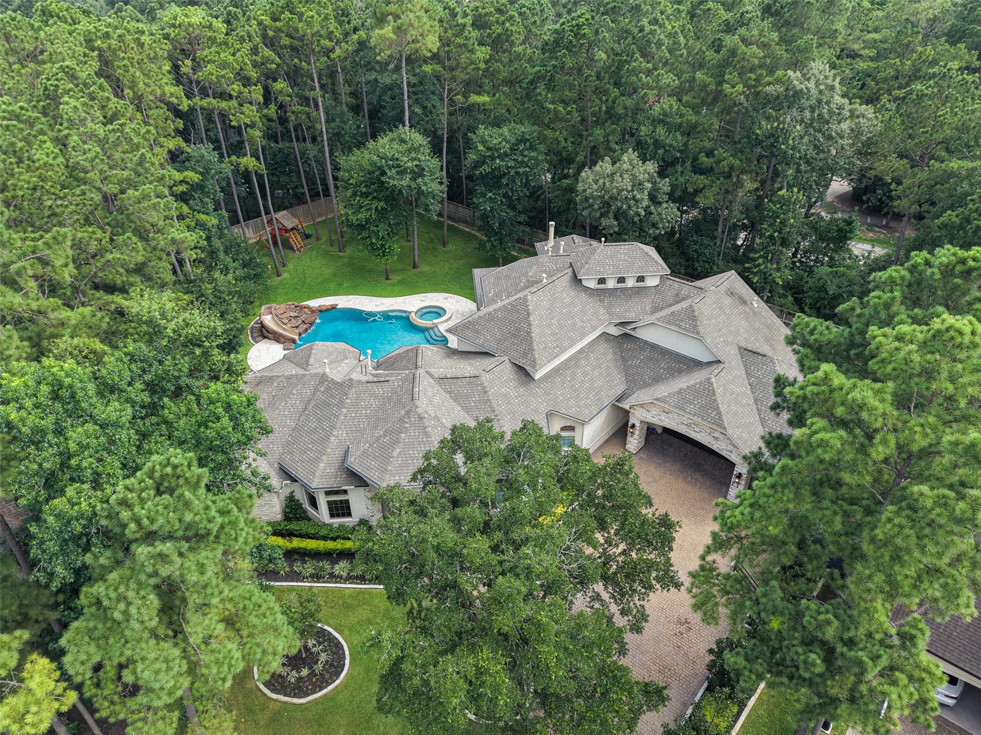 19 Harmony Links Place, The Woodlands, TX 77382 Welcome to 19 Harmony Links Place! This aerial view showcases the home's expansive 26,271 square foot lot, highlighting the exceptional privacy provided by mature trees that beautifully surround the property. The most peaceful setting with ample outdoor space to enjoy!