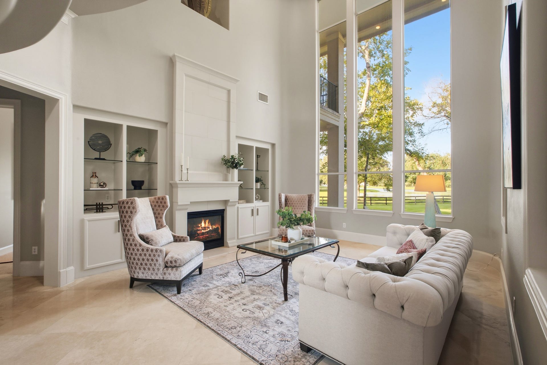3518 River Forest Drive, Richmond, TX 77406 Stunning living room with soaring ceilings, large windows offering picturesque views, elegant fireplace, and inviting seating area.