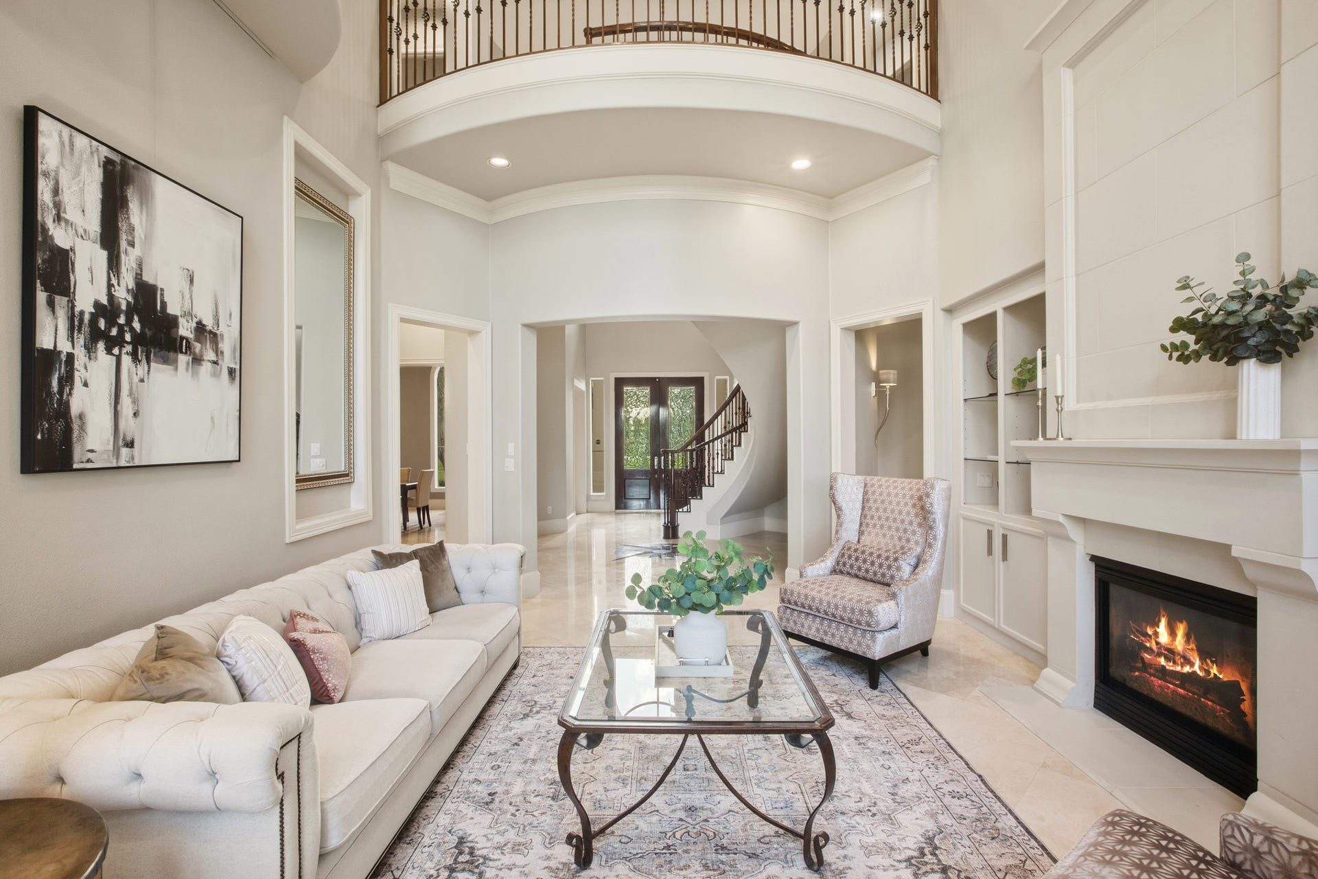 3518 River Forest Drive, Richmond, TX 77406 Elegant living room with high ceilings, a cozy fireplace, and a grand staircase.