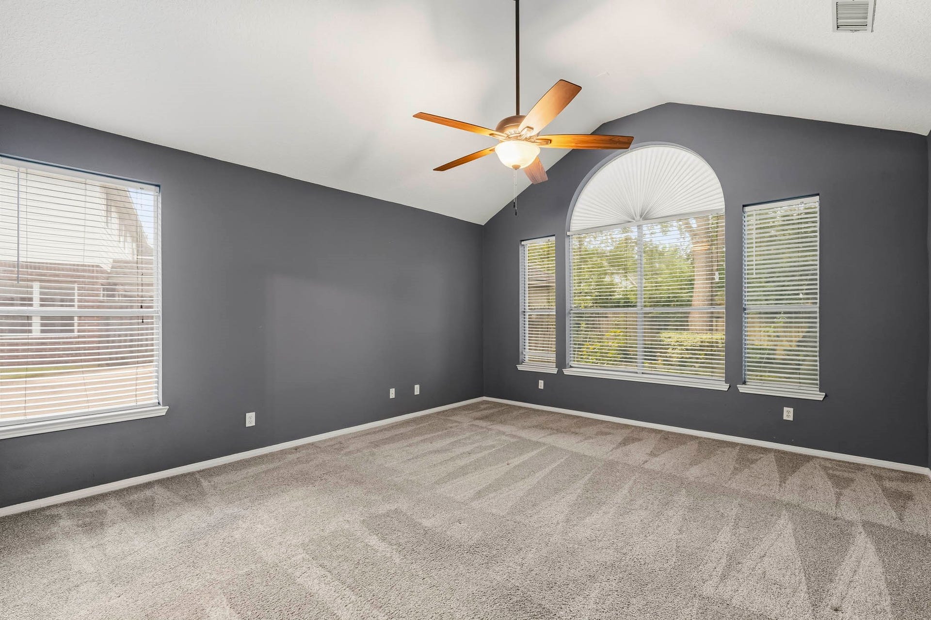 Relax in the oversized primary suite with soaring vaulted ceilings and large windows.
