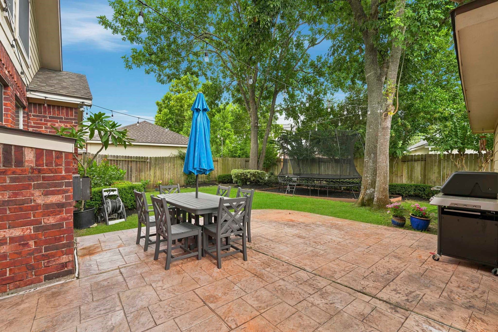 Charming extended patio perfect for dining outdoors and plenty of green space.