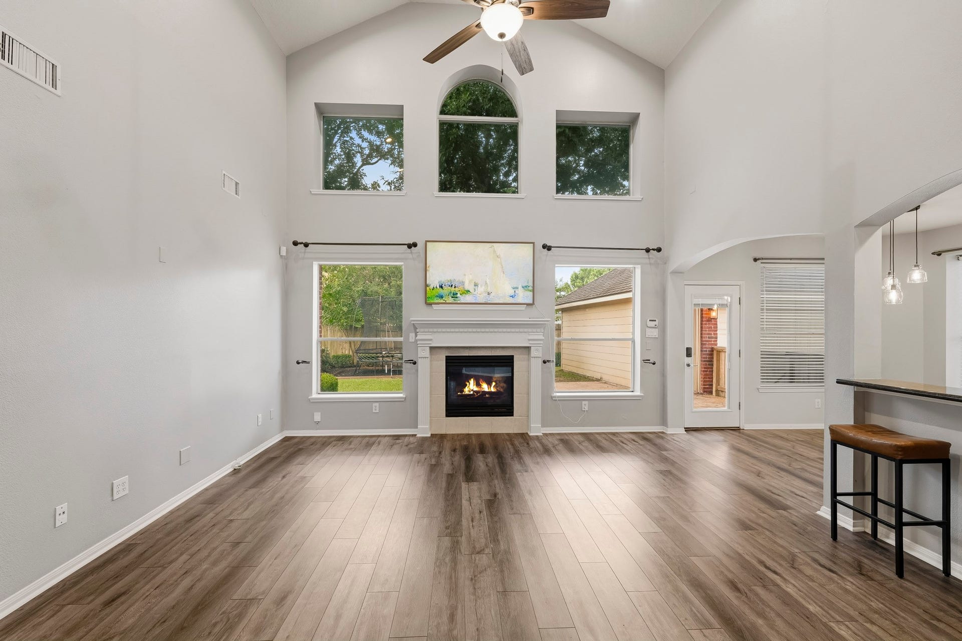Relax with the entire family in this expansive living room with soaring ceilings, a cozy fireplace, and a wall of windows that frame the beautiful outdoor views.