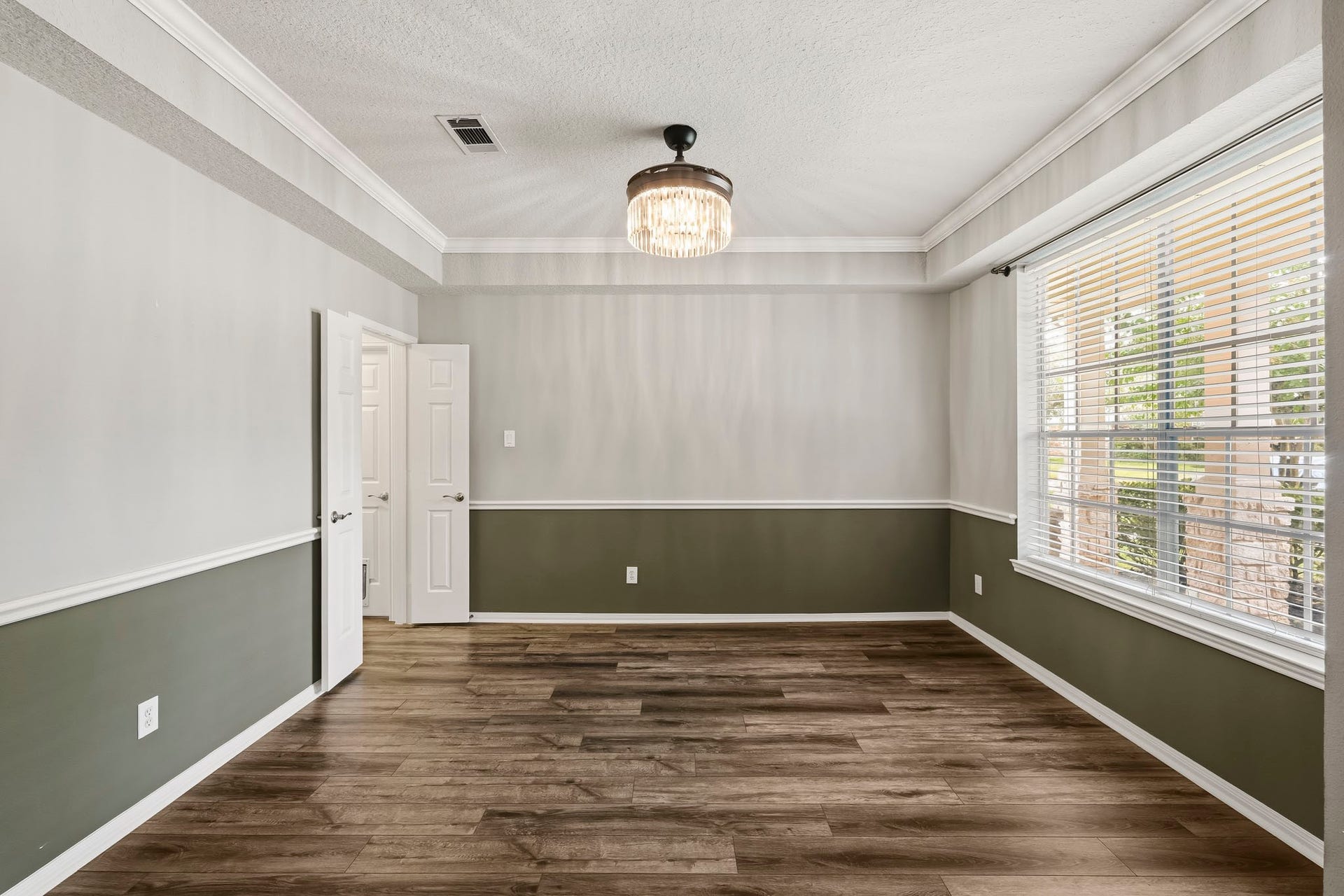 Light filled entryway leading to an elegant dining area with updated lighting.