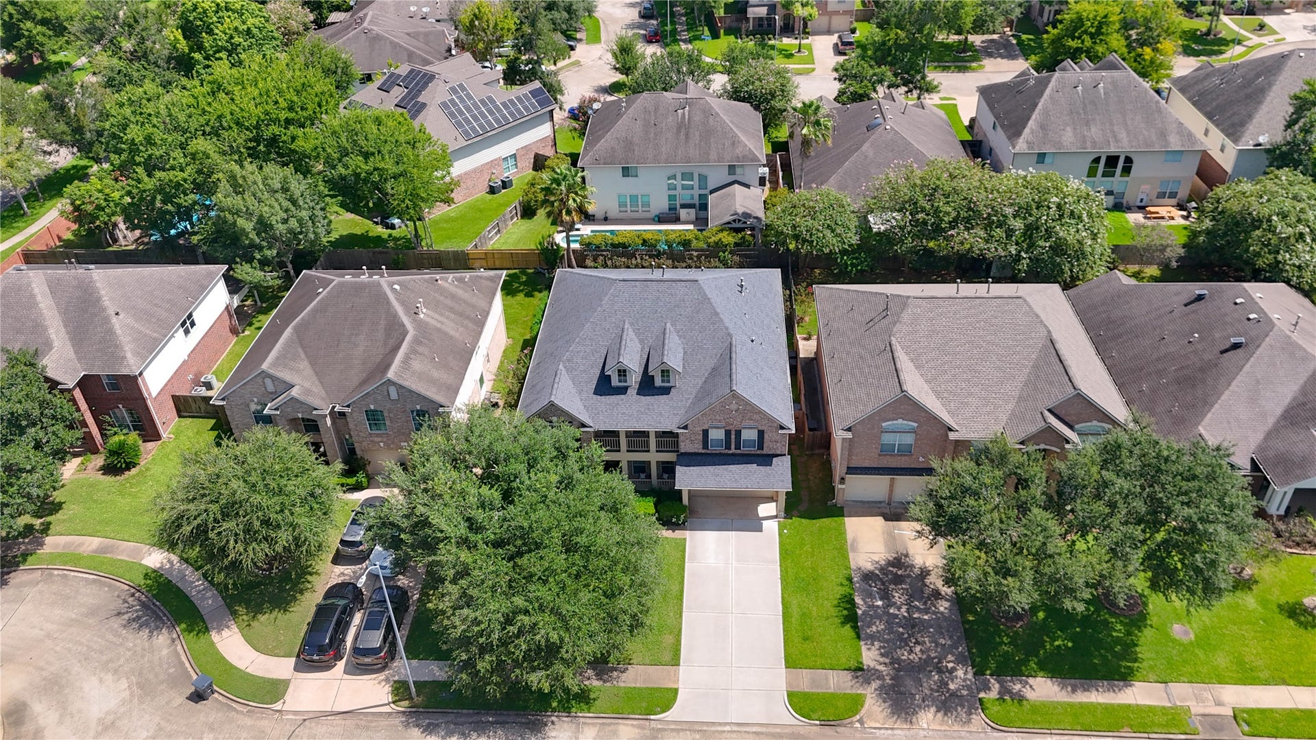 8111 Summer Wind Court, Sugar Land, TX 77479 Beautiful two-story home nestled in a tree-lined suburban neighborhood, featuring a spacious driveway and lush green lawn.