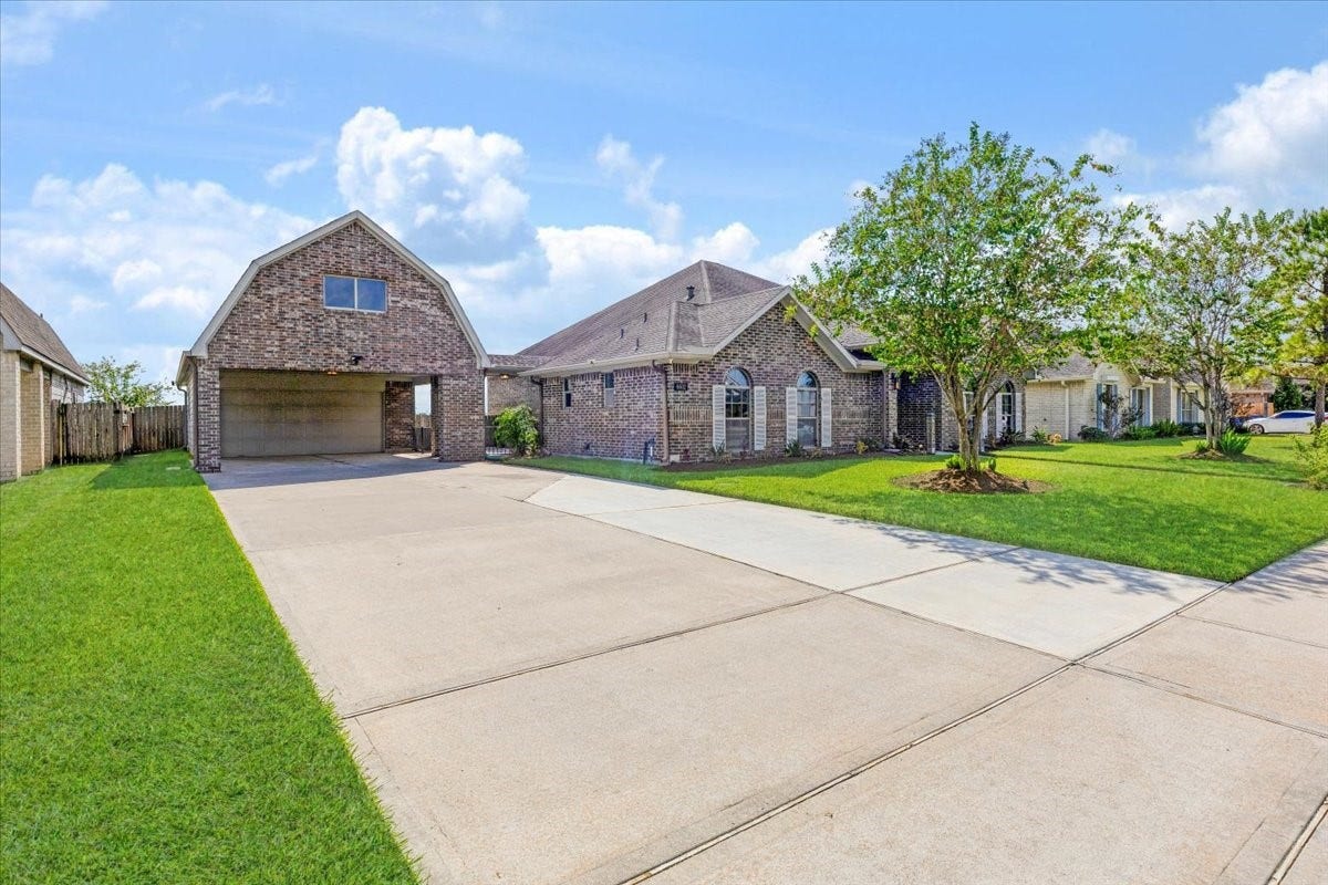 Space for the practical side of life. The detached garage, carport and broad driveway add valuable parking and storage options to this Manvel home, complementing the comfort found inside.