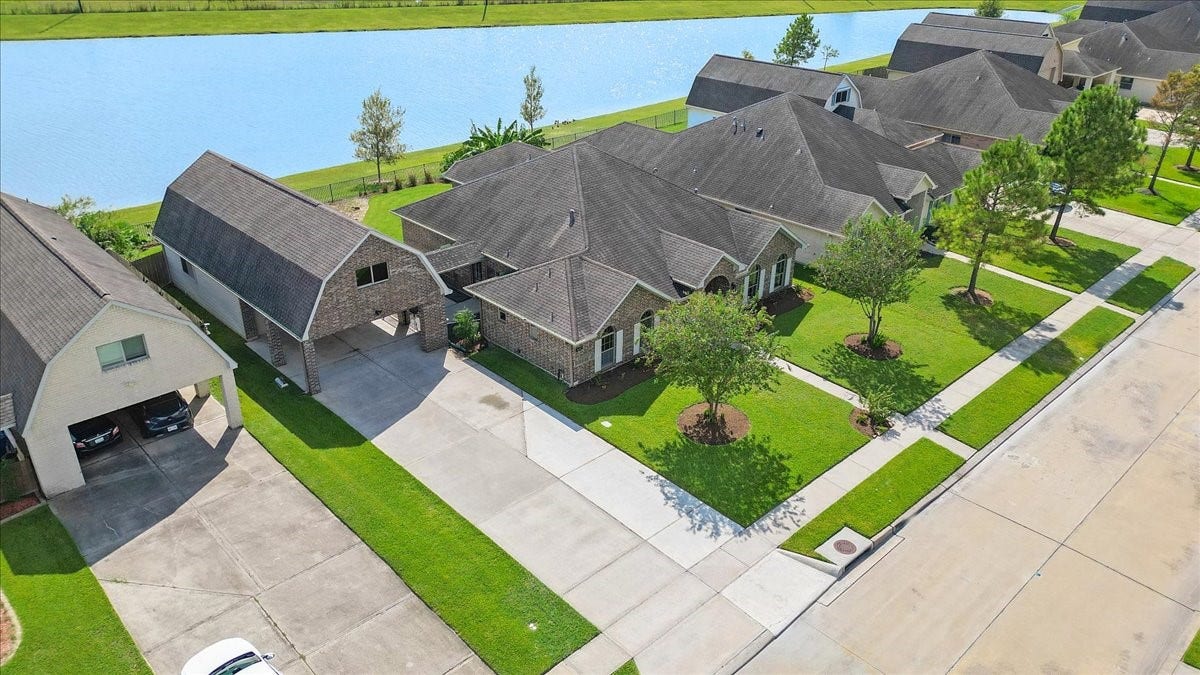 See what sets this Manvel lakefront home apart: water behind the backyard, room to spread out and the added utility of a detached garage. The aerial perspective brings the entire setting into view.