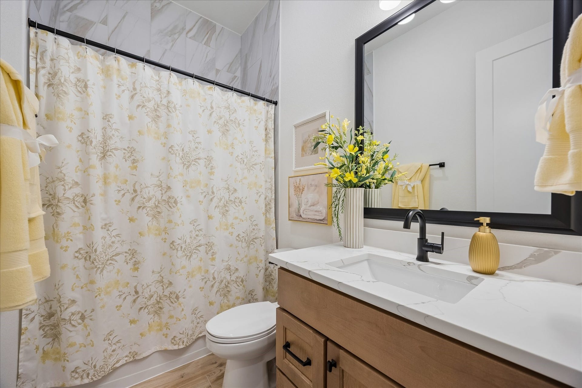 32438 Violet Dancer Court, Fulshear, TX 77441 Secondary bathroom features full height upgraded marble tile with matte black upgraded fixtures and framed mirror. Custom cabinetry and granite countertop gives an elevate appearance.