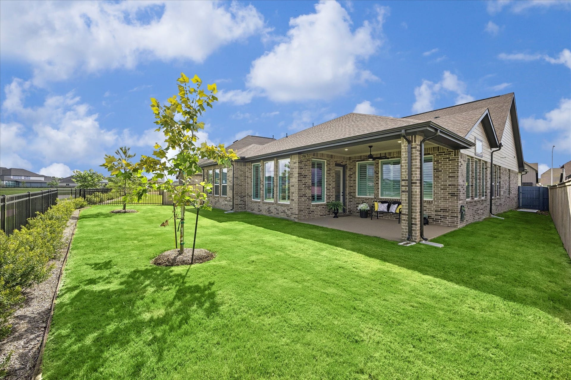 32438 Violet Dancer Court, Fulshear, TX 77441 Backyard, patio, and side yard. Home features full home sprinkler system, gutters, and concrete trash can pad.