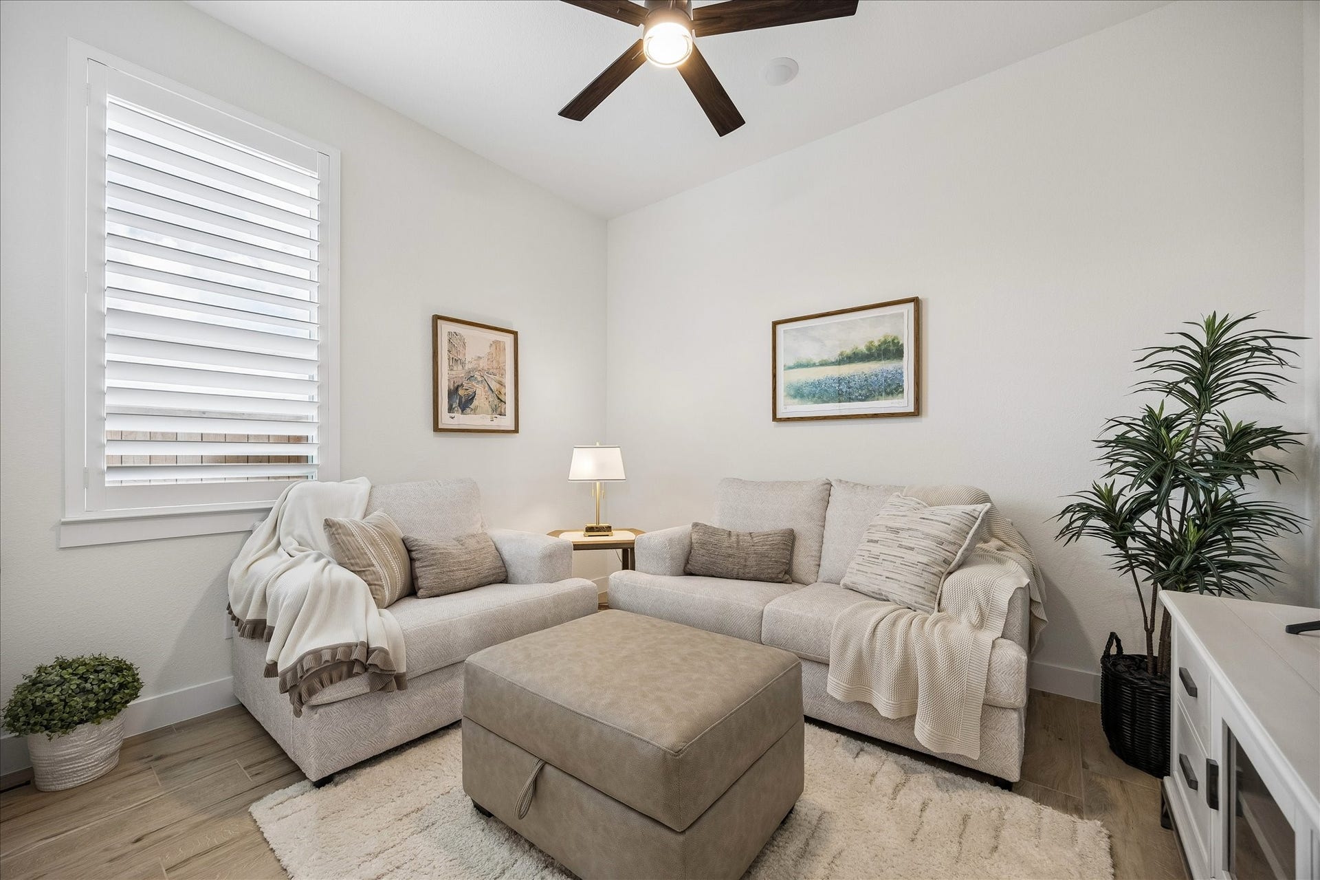 32438 Violet Dancer Court, Fulshear, TX 77441 The second bedroom features custom plantation shutters, wood-plank tile flooring, and a ceiling fan. This versatile space is ideal as a guest room, childrens bedroom, hobby room, or entertainment area, as shown.