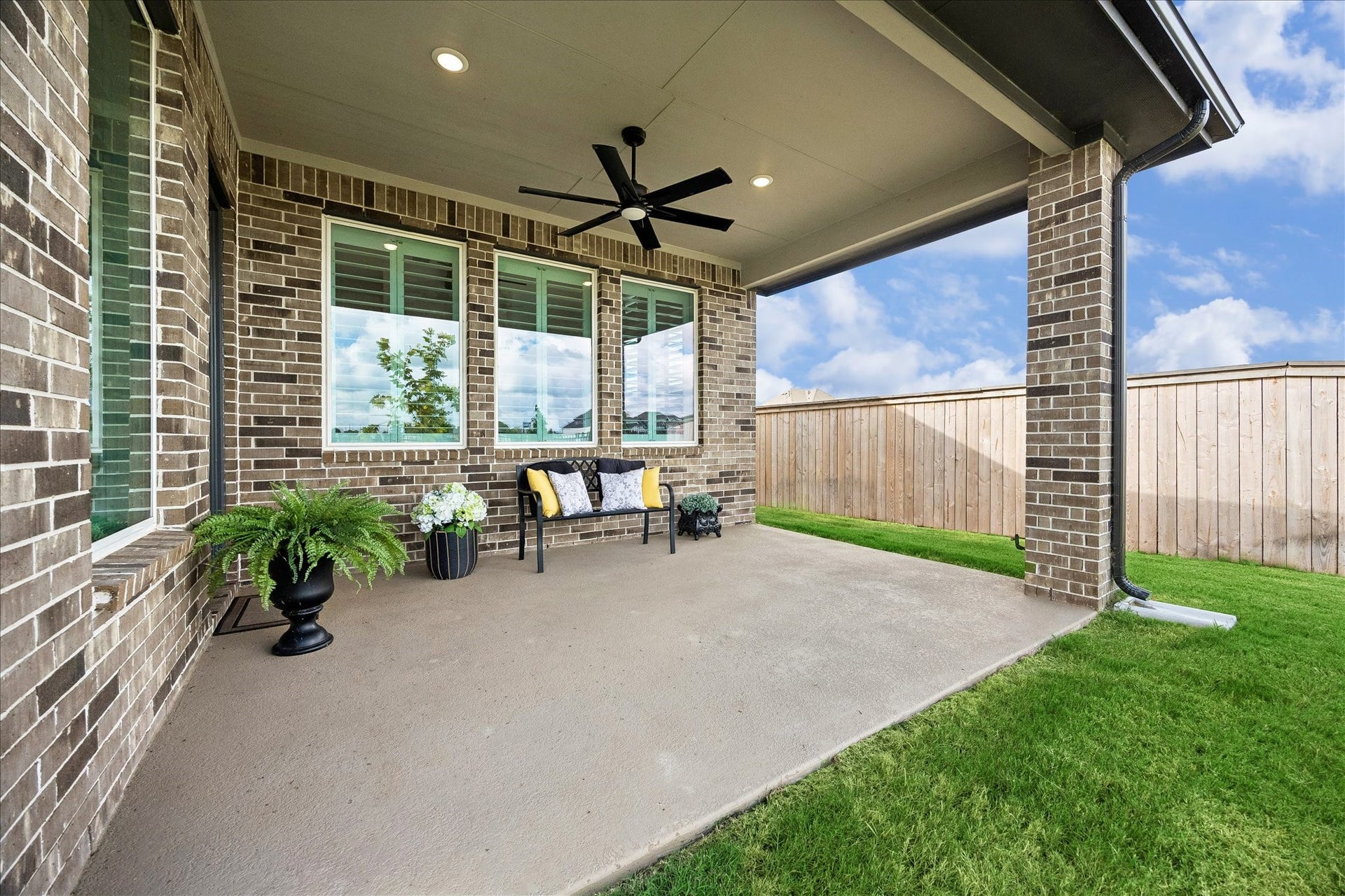 32438 Violet Dancer Court, Fulshear, TX 77441 This covered patio expands your living space, featuring recessed lighting, a ceiling fan, and stylish brick accents. Enjoy seamless indoor-outdoor living through a wall of windows, with a gas hook-up ready for your dream outdoor kitchen. The patio overlooks the backyard, offering peaceful views of the water and trails.