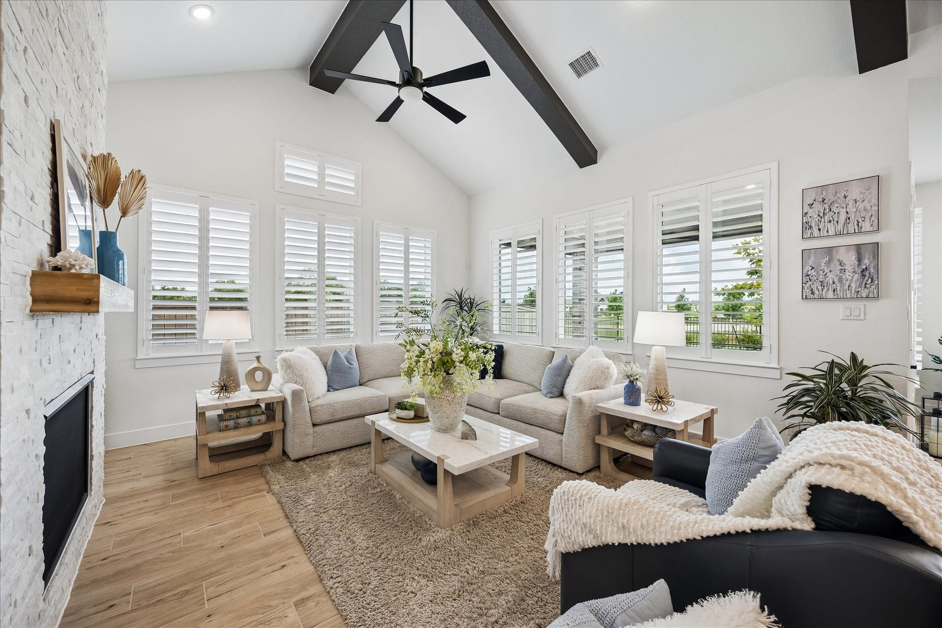 The living room features tranquil views of the patio, water and nature.