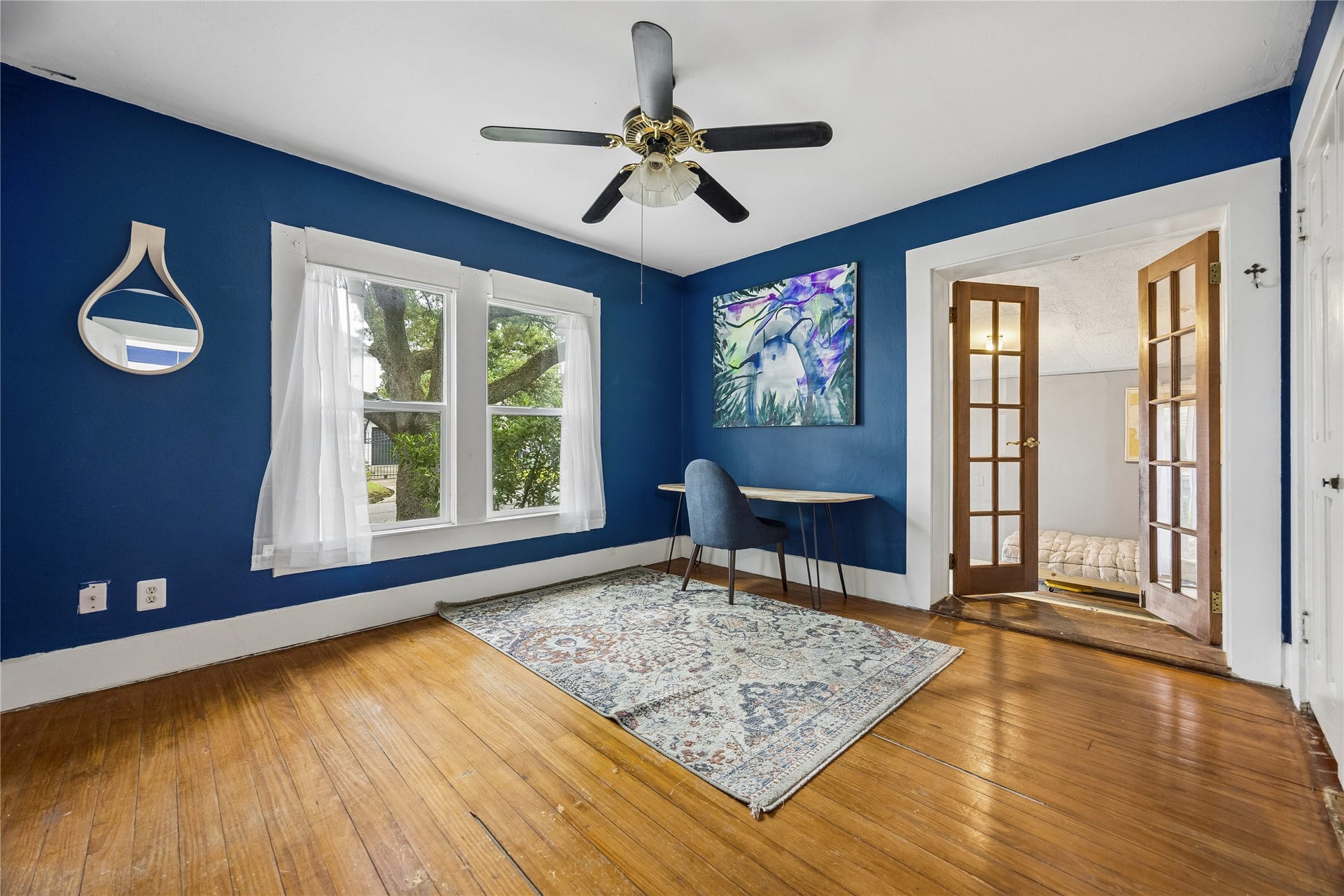 1039 Dunbar Street, Houston, TX 77009 Rich blue walls and warm wood floors give this light-filled room plenty of personality, while French doors provide a graceful transition into the adjoining space.