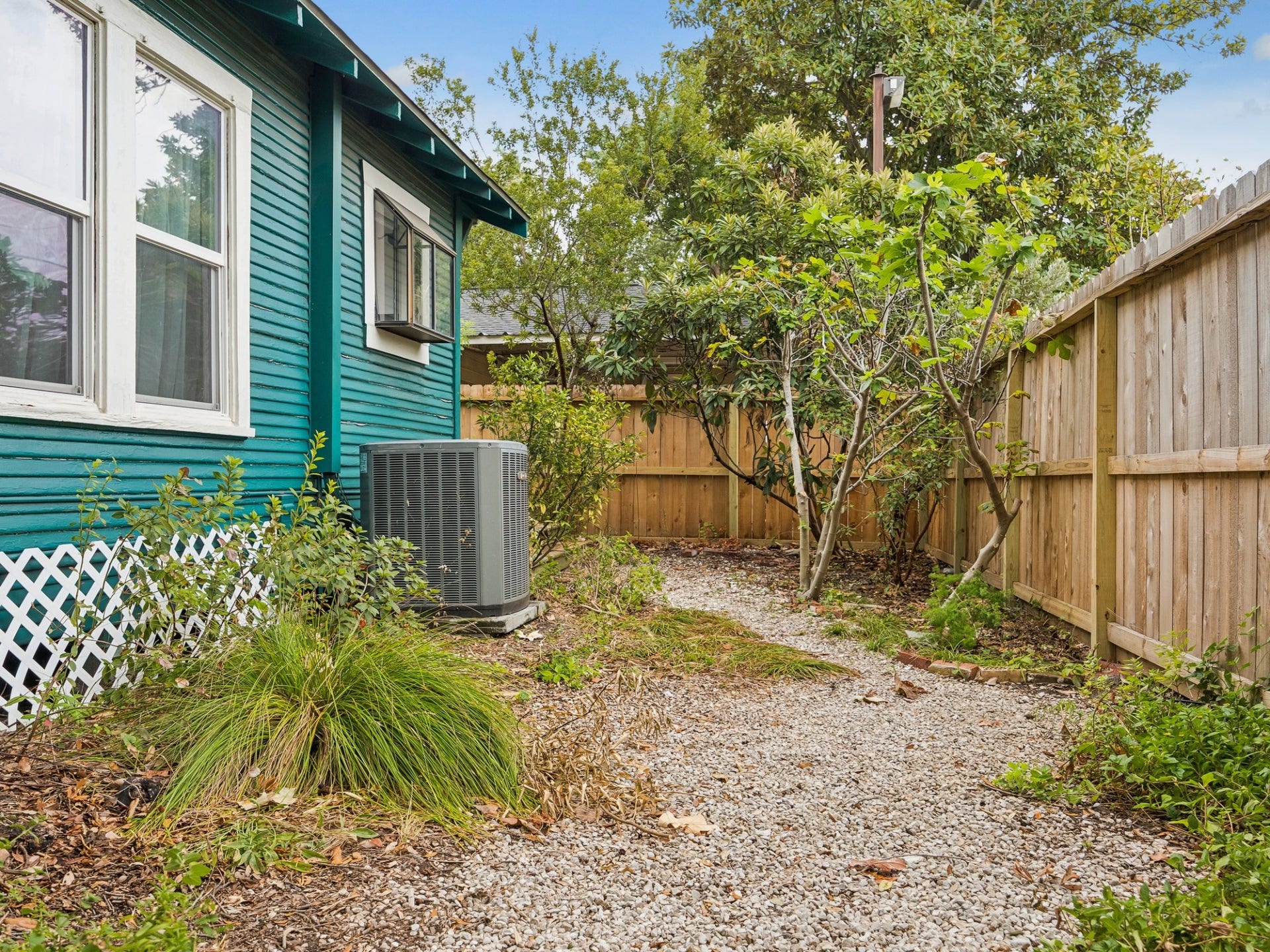 1039 Dunbar Street, Houston, TX 77009 A fenced side yard with a winding gravel path and established plantings adds another charming outdoor dimension to the property.