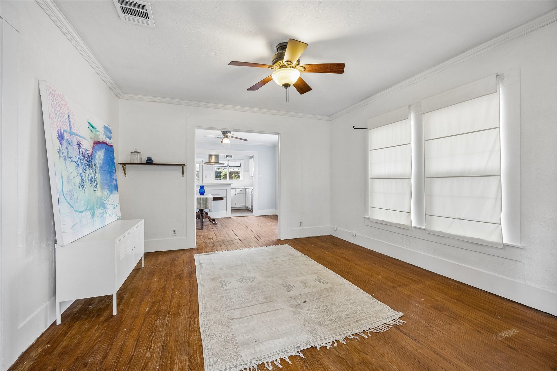 1039 Dunbar Street, Houston, TX 77009 Opposing view of the spacious main living area which pairs beautiful wood flooring with tall windows and an easy flow into the adjoining dining and kitchen spaces, creating an open, connected feel.