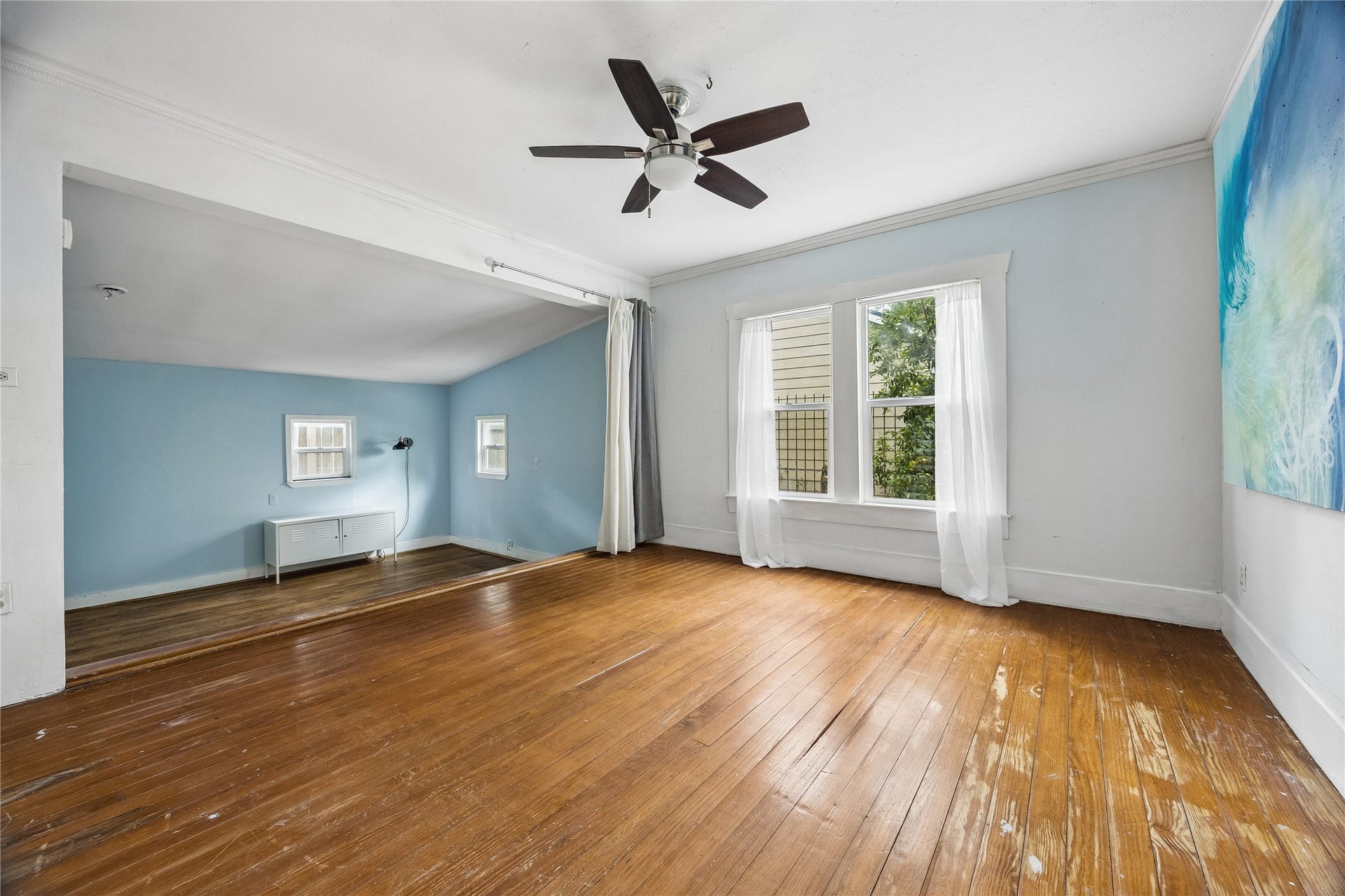 1039 Dunbar Street, Houston, TX 77009 Natural light pours into this generously sized room, highlighting its wood floors, ceiling fan, and open connection to an additional flexible living area.