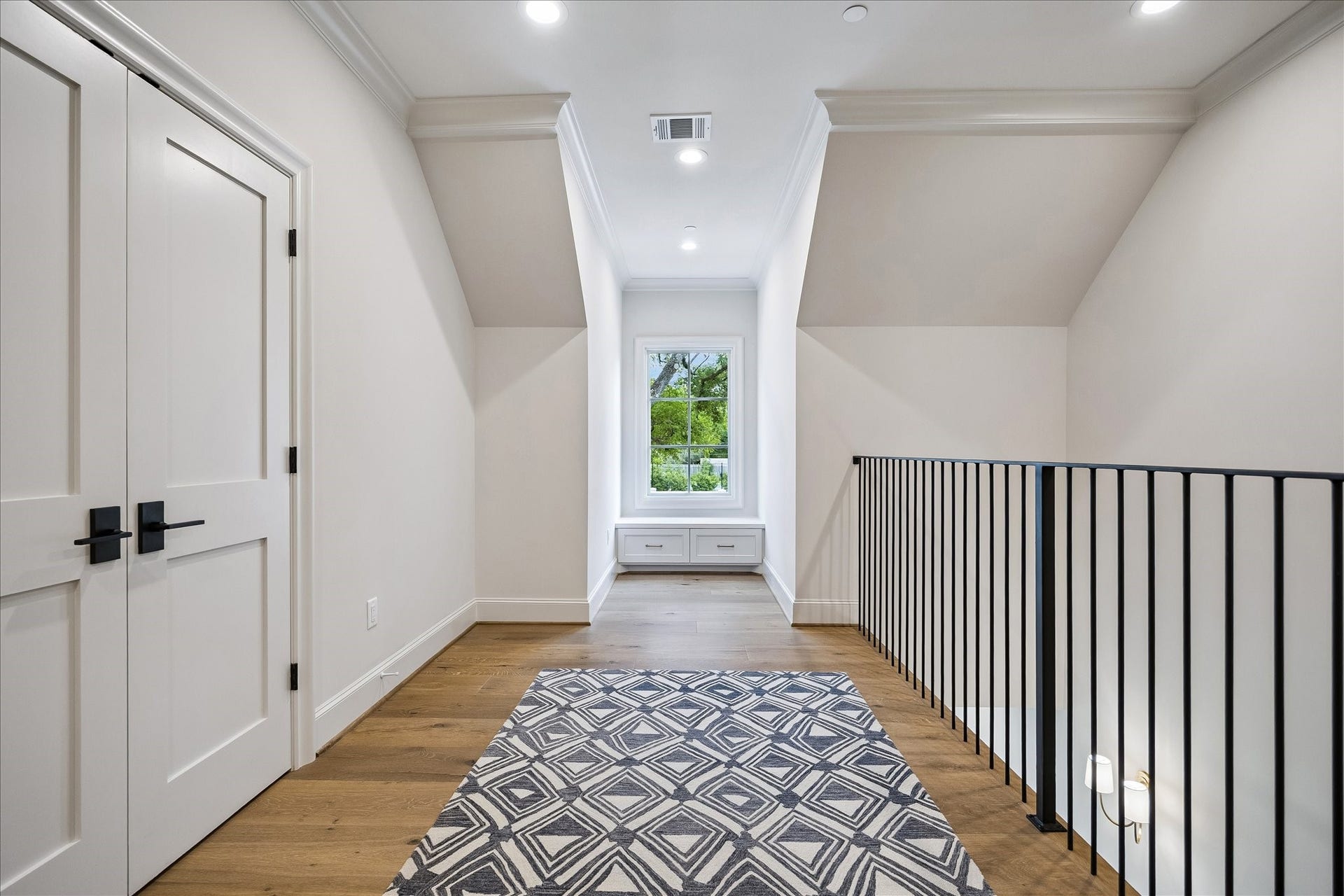 10801 Long Shadow Lane, Hunters Creek Village, TX 77024 Light-filled upper-level landing featuring beautiful wide-plank French white oak flooring, enhanced by crown molding and lovely trim. A charming window seat offers a cozy nook framed by natural light, while the open railing adds architectural interest and overlooks the level below. Versatile in design, ideal for play area, reading or additional lounge area.