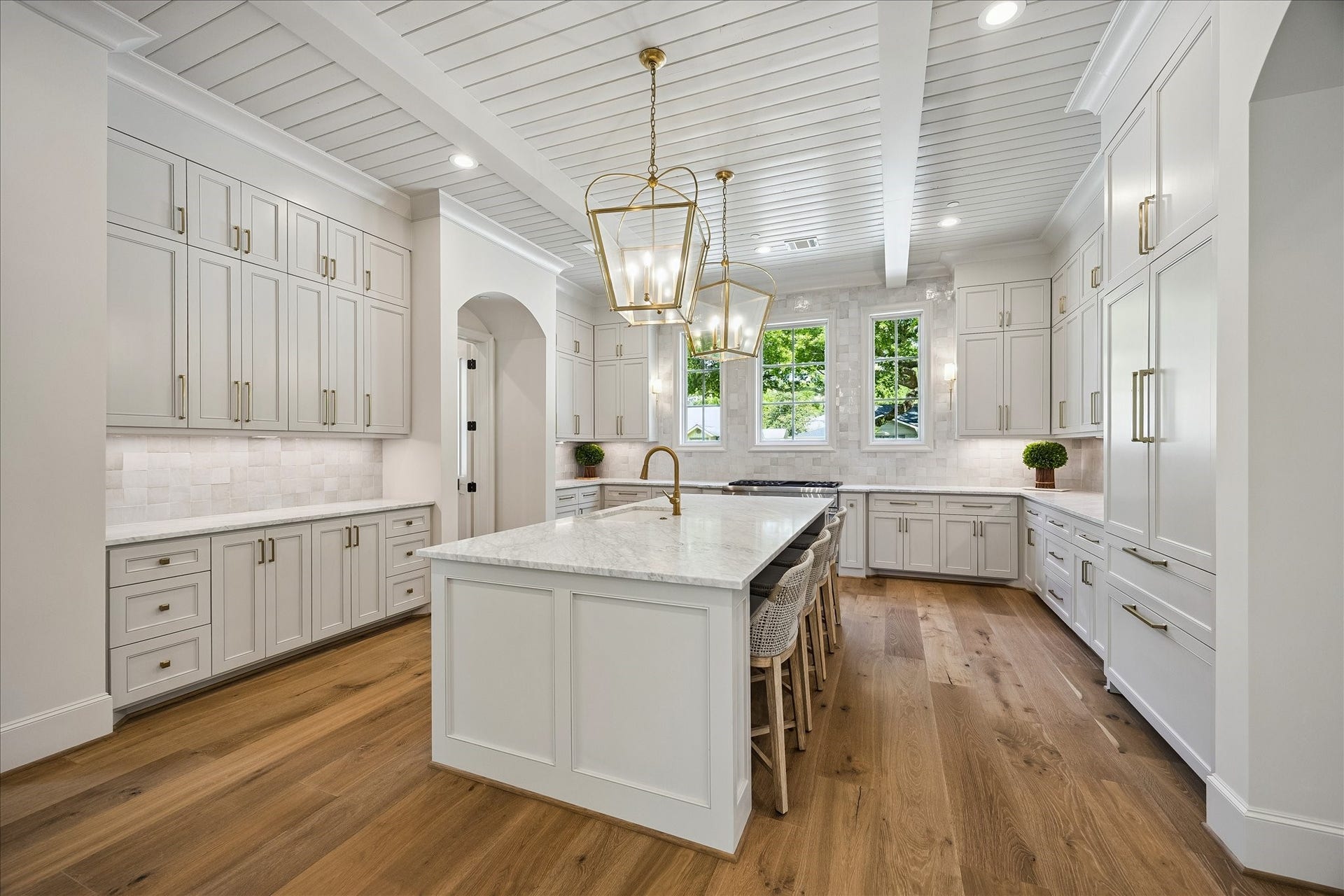 10801 Long Shadow Lane, Hunters Creek Village, TX 77024 Another view of this fabulous kitchen highlights the expansive island with seating, gorgeous Zellige tile backsplash and extensive custom cabinetry throughout. Thermador 48 gas range, built-in refrigerator, dishwasher and microwave are paired with marble surfaces and thoughtfully designed storage for a polished, functional space. We love the gorgeous hardware and the view through the windows of the lovely street! Looking for light and bright---you have found it!