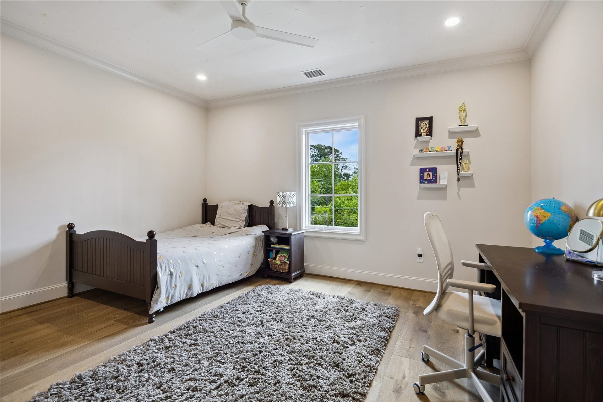 10801 Long Shadow Lane, Hunters Creek Village, TX 77024 Charming large secondary bedroom featuring hardwood flooring, crown molding, recessed lighting, modern ceiling fan and a large divided light window that fills the space with natural light and serene views.