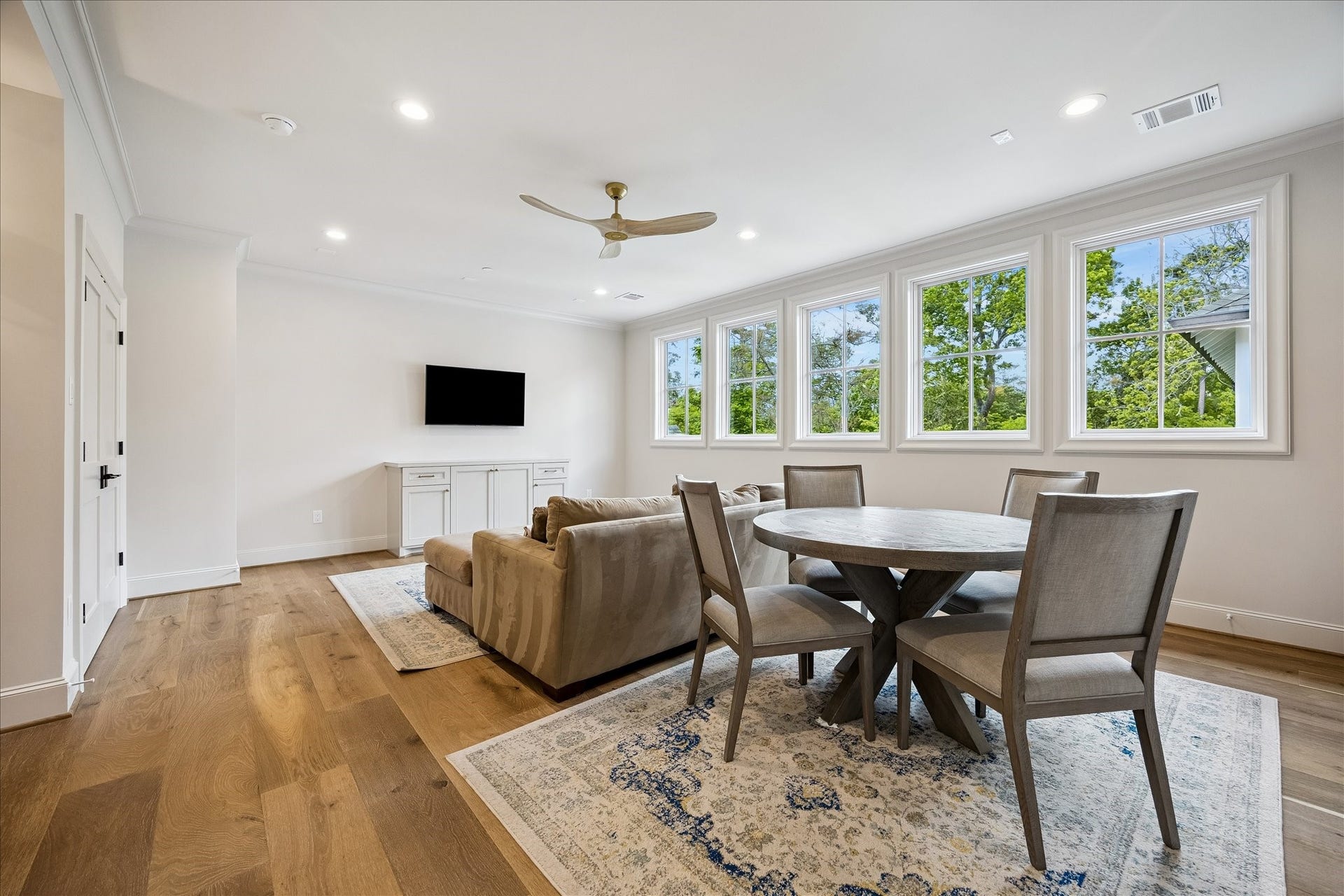 10801 Long Shadow Lane, Hunters Creek Village, TX 77024 Spacious and light-filled game room featuring wide-plank French white oak flooring, crown molding & beautiful trim throughout. A wall of divided light windows brings in abundant natural light and overlooks the treetops, creating an inviting and functional atmosphere. Thoughtfully designed area which can be used for lounging and playing games.