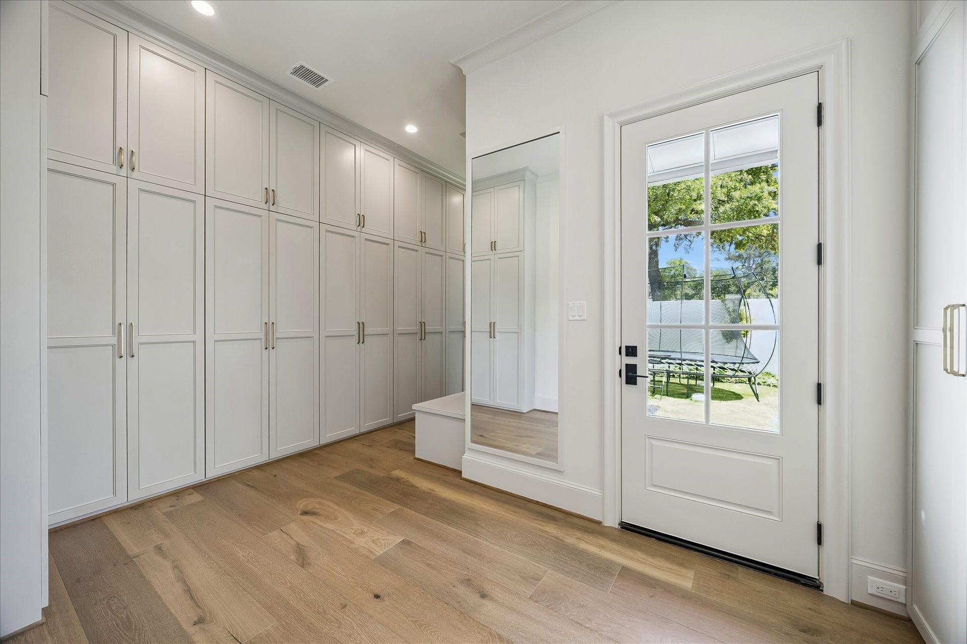10801 Long Shadow Lane, Hunters Creek Village, TX 77024 The primary closet features wall of extensive custom-built cabinetry with integrated hanging, shelving and storage space. Beautiful French white oak wide plank flooring continues throughout, while a full-length mirror and direct exterior access to the side yard add convenience and a refined finishing touch.