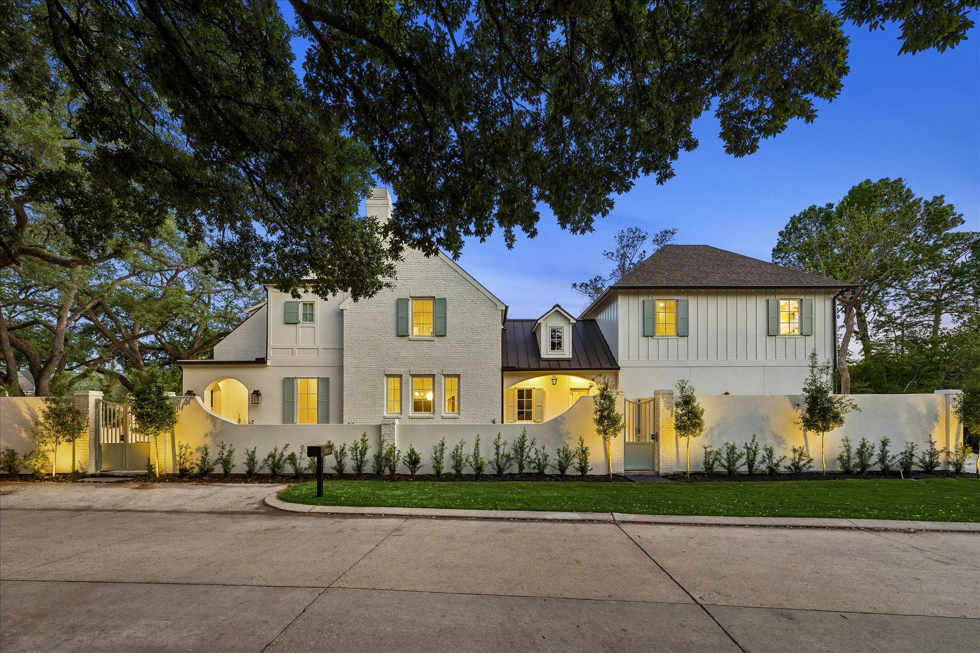 10801 Long Shadow Lane, Hunters Creek Village, TX 77024 Beautifully illuminated exterior showcasing timeless architecture, gated courtyard walls & professionally designed landscape lighting. Mature trees frame the property while the warm interior glow highlights the inviting presence at dusk. We love this additional parking space for convenience!