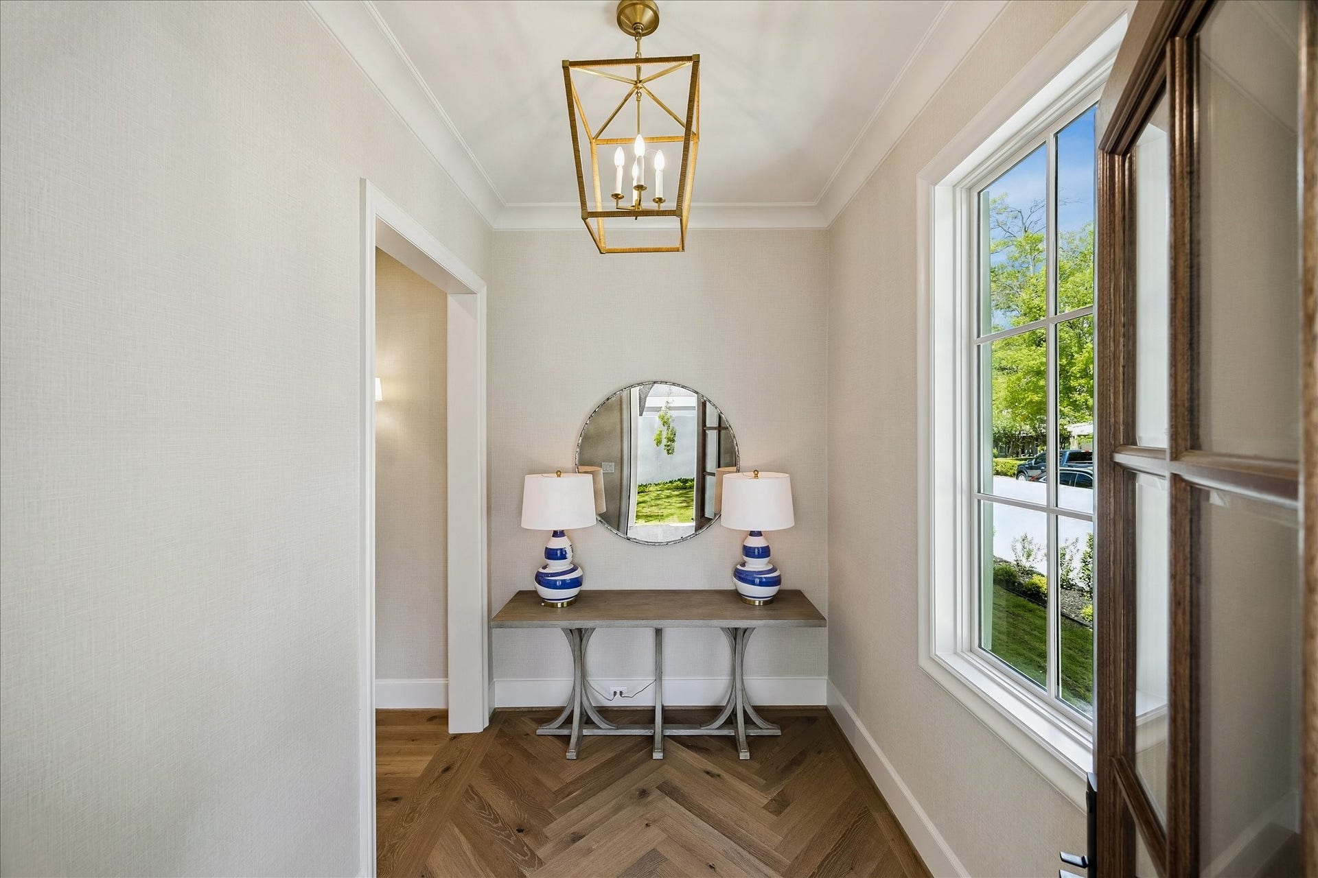 10801 Long Shadow Lane, Hunters Creek Village, TX 77024 Elegant front entry featuring herringbone hardwood floors, designer lighting and refined trim details. Large divided light window fills the space with natural light and creates a beautiful introduction to the home.