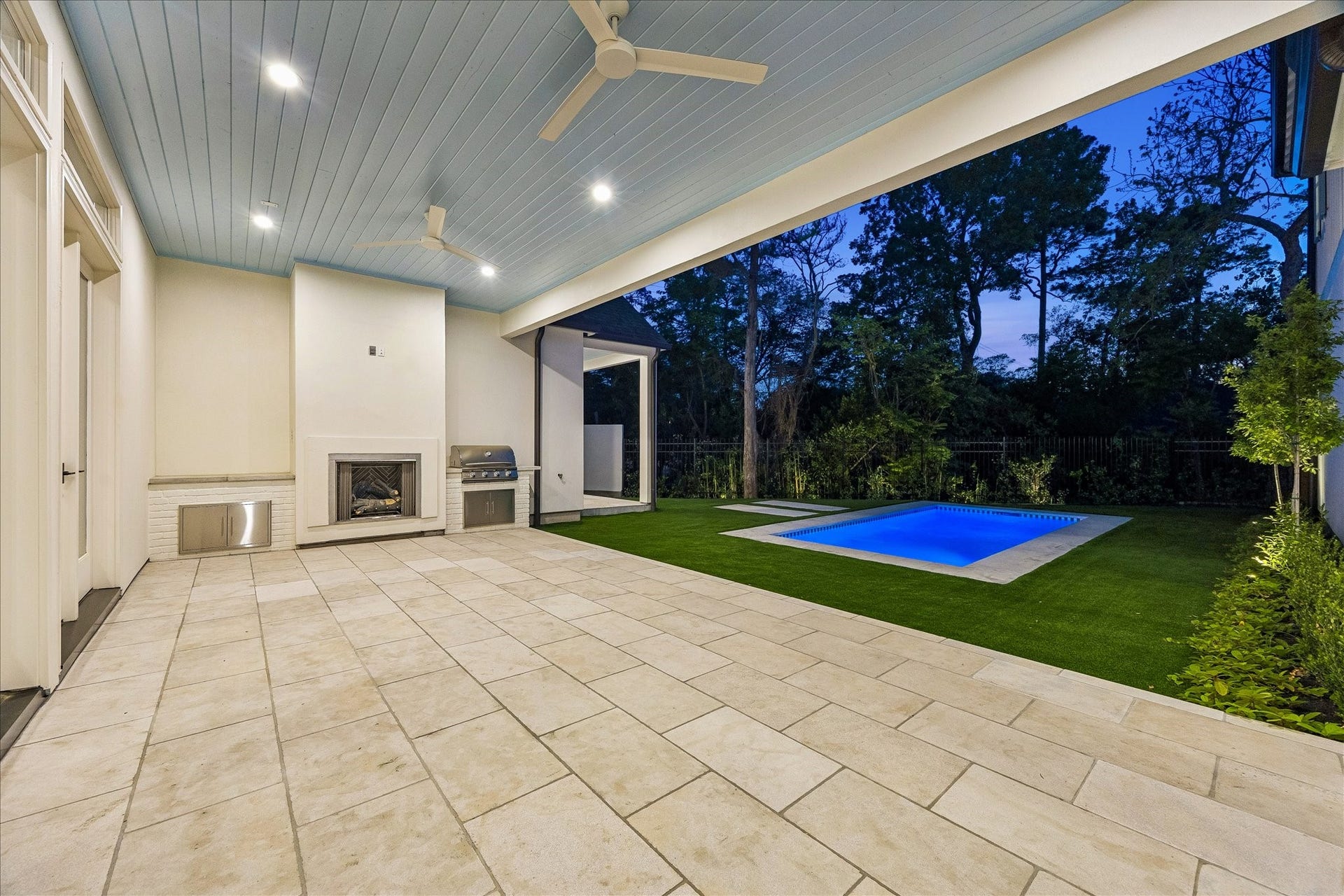 10801 Long Shadow Lane, Hunters Creek Village, TX 77024 Covered outdoor area with tumbled limestone flooring, gas log fireplace & Blaze outdoor grill. Painted custom ceiling with fans and recessed lighting overlooks the turf & beautiful pool, creating a seamless indoor-outdoor relaxation and/or entertaining space. Go ahead and plan your next Pool Party!