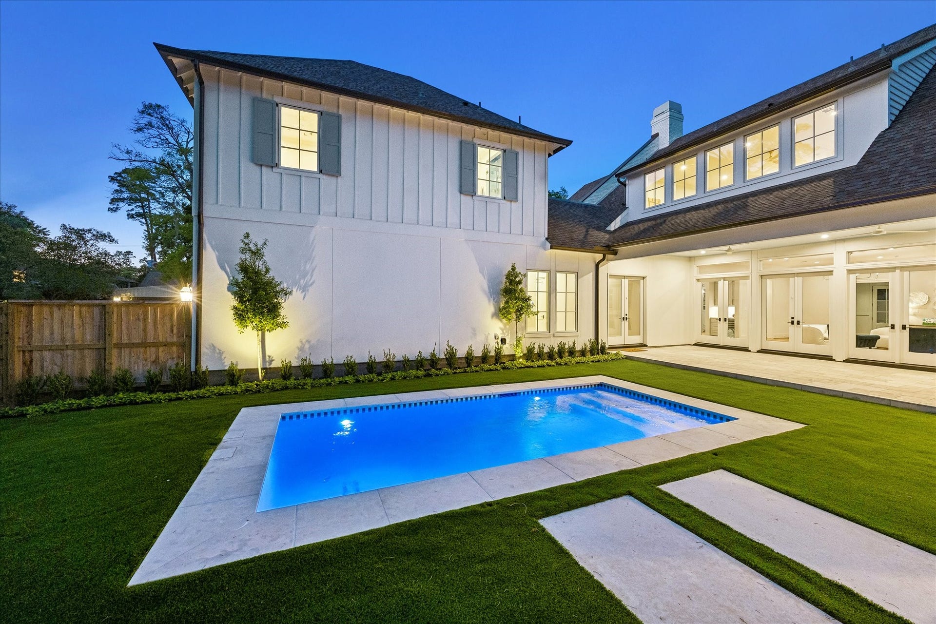 10801 Long Shadow Lane, Hunters Creek Village, TX 77024 This perspective highlights the designated covered relaxation areas surrounding the pool, offering flexible space for seating. The turf extends throughout the backyard while lighted trees create a natural backdrop & soft evening lighting to bring the outdoors in!