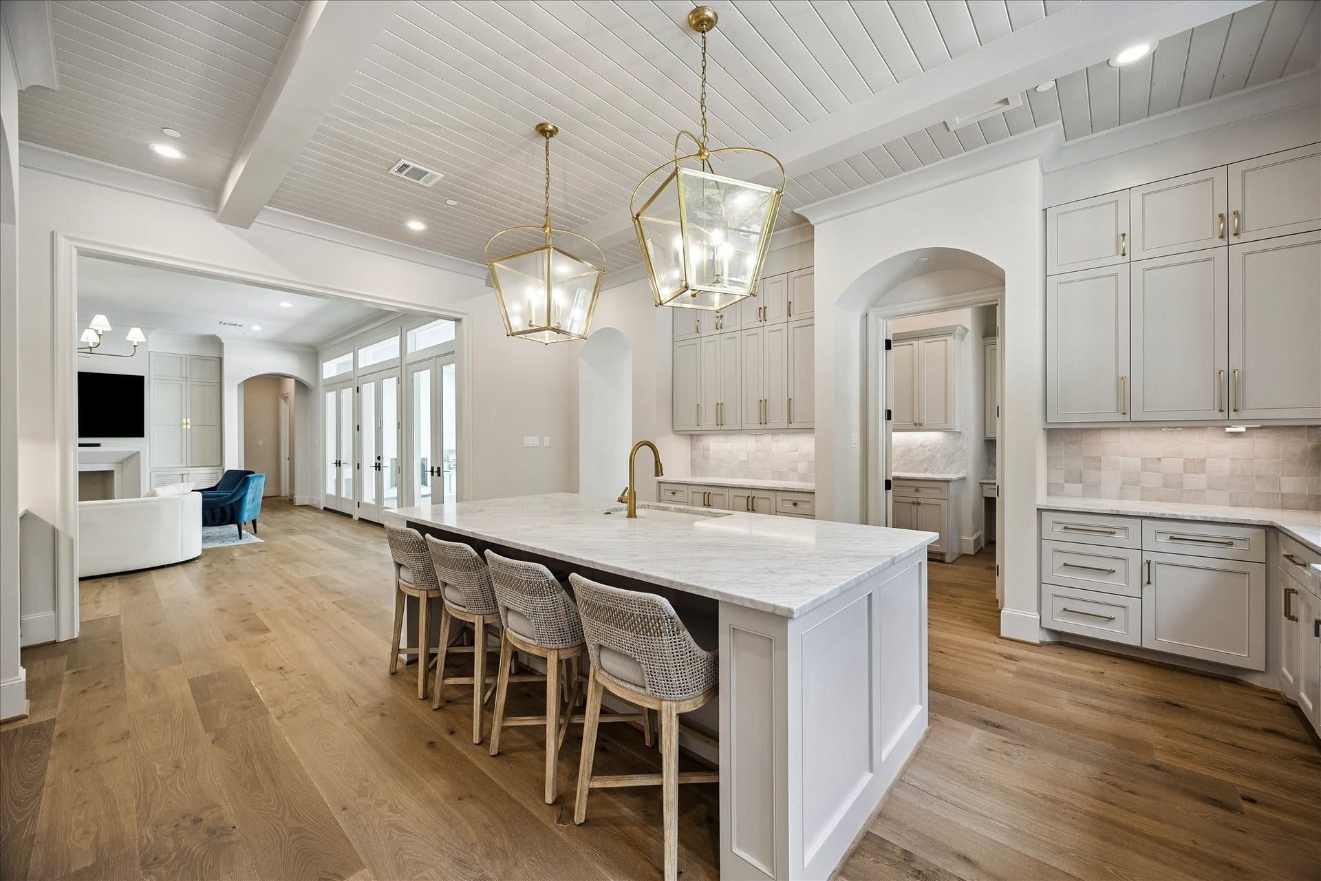 10801 Long Shadow Lane, Hunters Creek Village, TX 77024 Incredible chefs kitchen opens to the living area featuring a large island with breakfast bar seating, honed marble slab countertops, gorgeous tile backsplash and lantern pendant lighting. Custom built cabinetry, under-cabinet lighting and soft-close drawers and doors are complemented by high-end Thermador stainless appliances and a Blanco undermount sink.