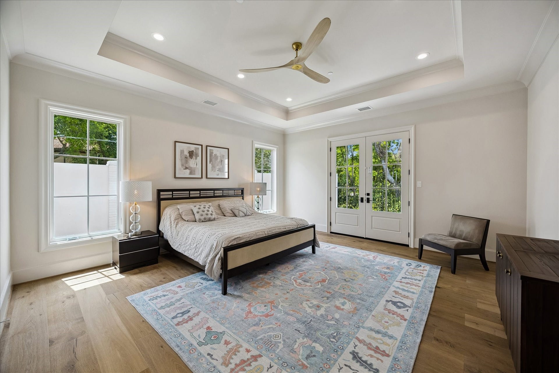 10801 Long Shadow Lane, Hunters Creek Village, TX 77024 The primary suite offers a serene retreat with beautiful French white oak wide plank flooring, soaring ceilings with a tray detail, and crown molding. Divided light French doors open to the backyard and wooded ravine, bringing in natural light and creating a peaceful indoor-outdoor connection. The spacious layout allows for many decorating/furnishing options!