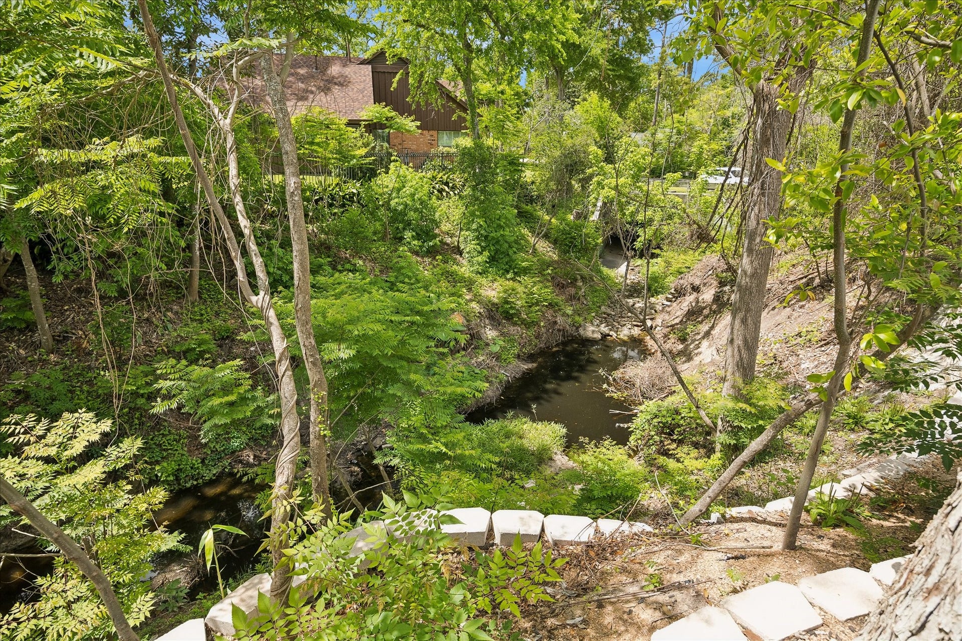 10801 Long Shadow Lane, Hunters Creek Village, TX 77024 View of the wooded ravine showcasing the extended retaining wall & enhanced drainage improvements. Thoughtful grading supports the backyard above while preserving the natural landscape. GORGEOUS!!!!