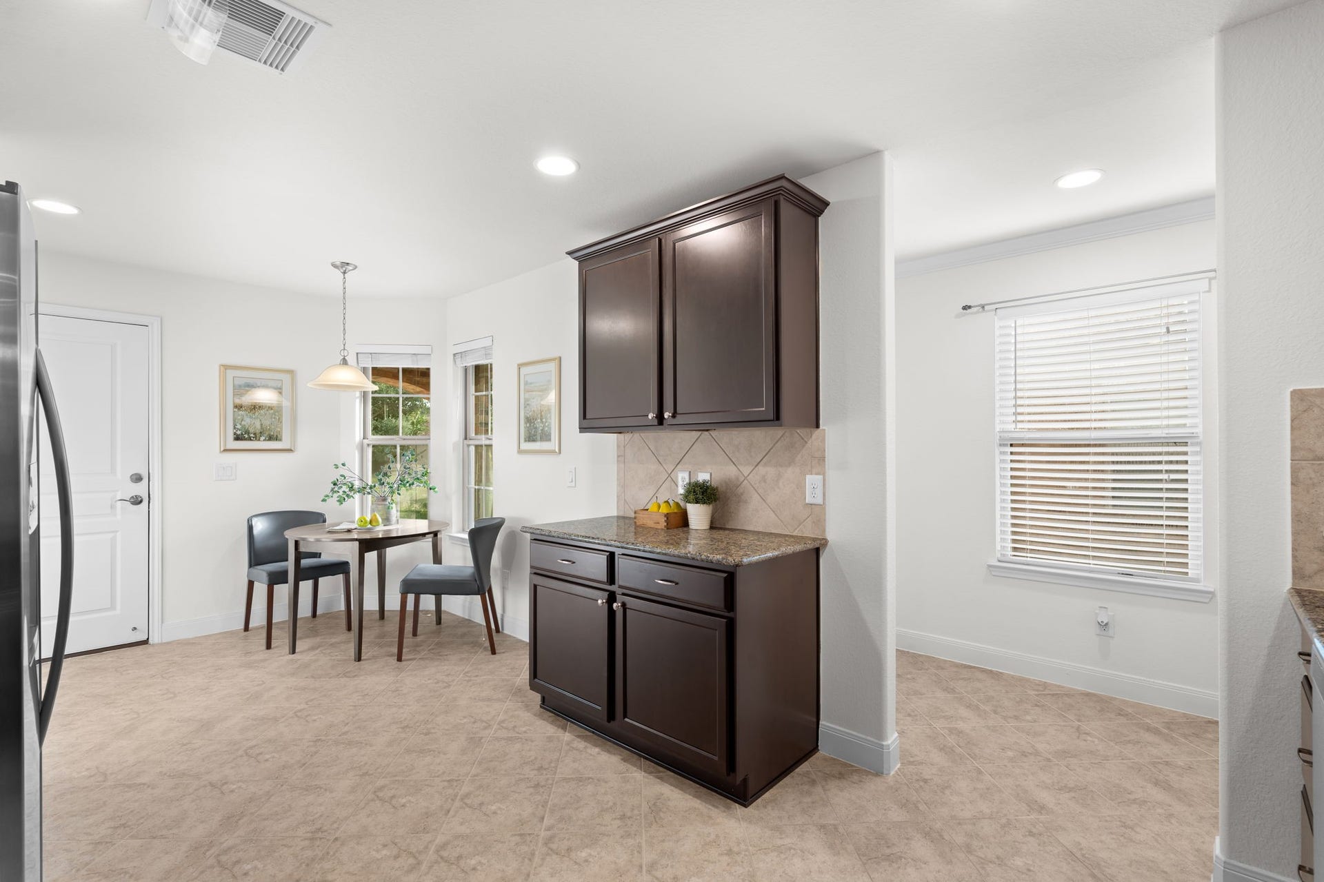 2938 Cone Flower Drive, Richmond, TX 77469 Warm cabinetry creates an inviting atmosphere in this practical kitchen!