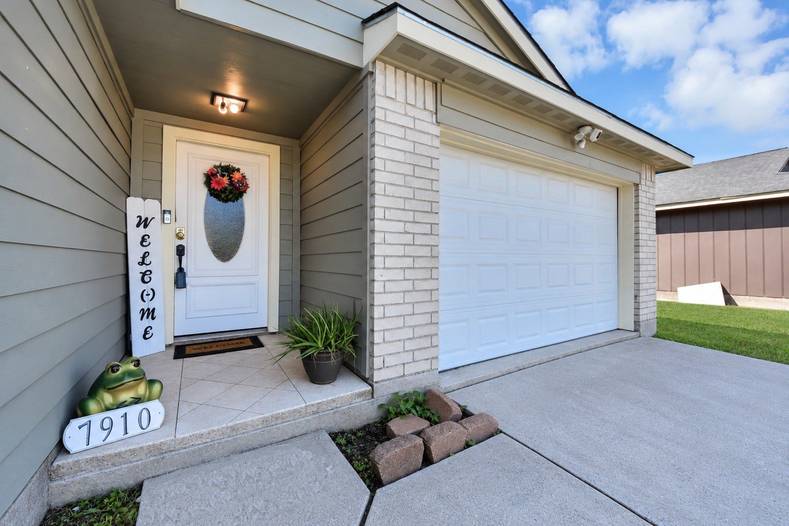 Charming covered front porch featuring updated exterior siding, a decorative glass entry door, and welcoming accents. A beautiful first impression that invites you into this lovely home!