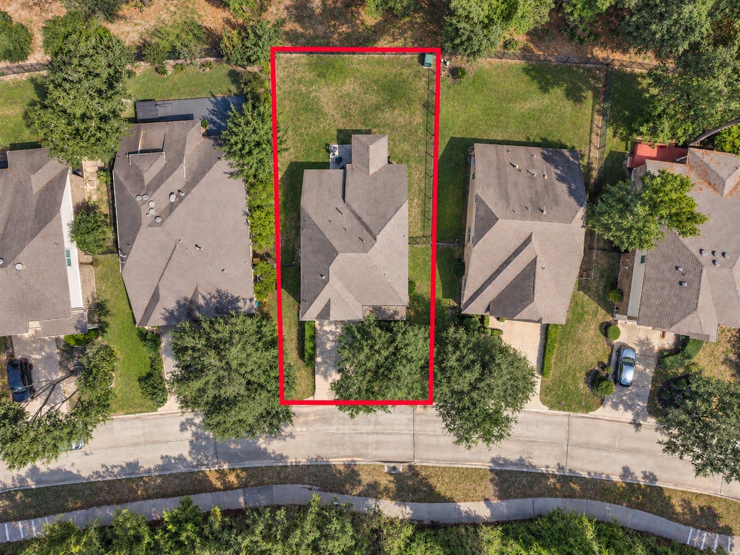 78 Heritage Mill, The Woodlands, TX 77375 This aerial view highlights the home's spacious waterfront lot, outlined in red, with a generous backyard and beautiful natural surroundings. Enjoy added privacy and scenic lake views in the heart of Creekside Park.