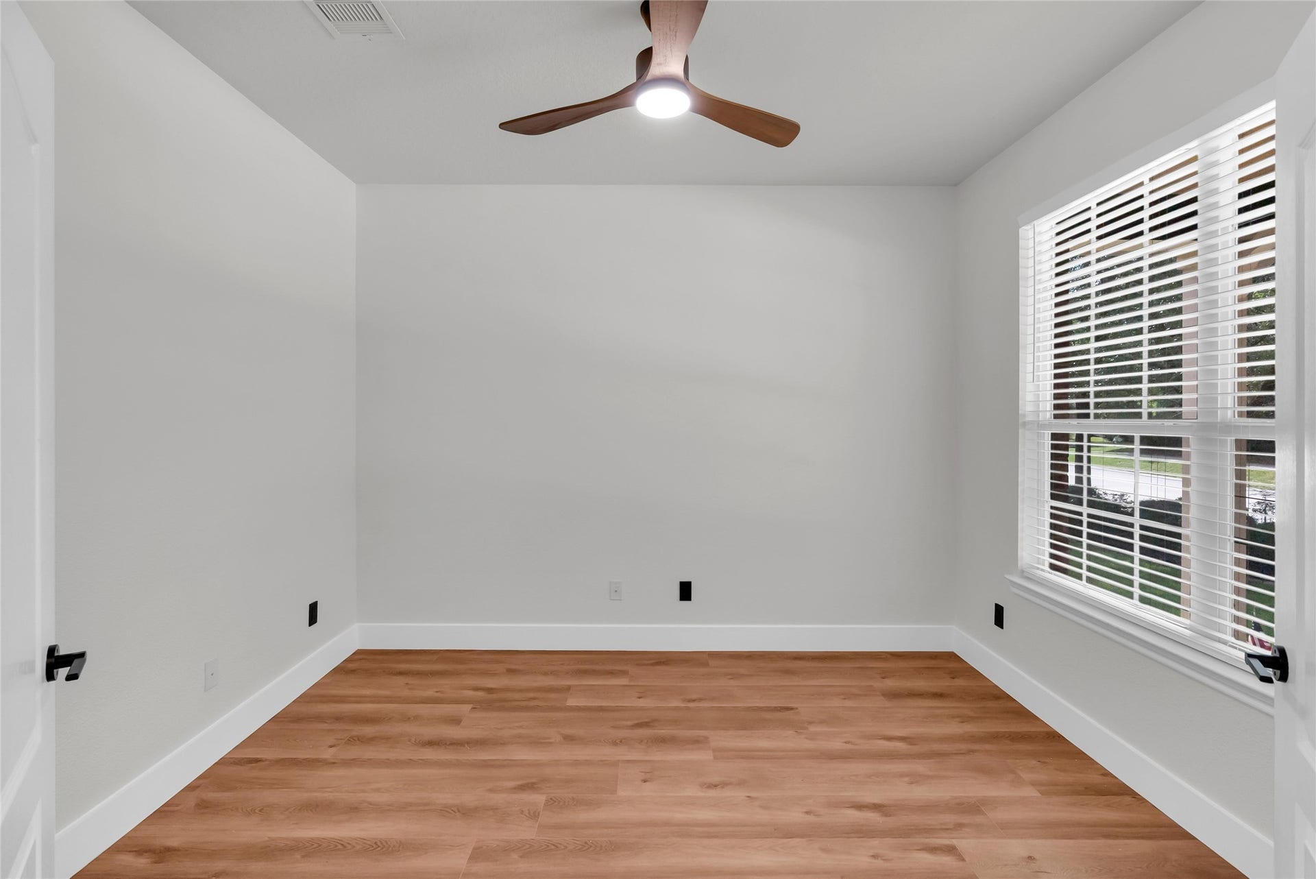 78 Heritage Mill, The Woodlands, TX 77375 A beautiful private home office with elegant glass French doors, abundant natural light, and warm wood flooring offers a bright, peaceful space to work from home.