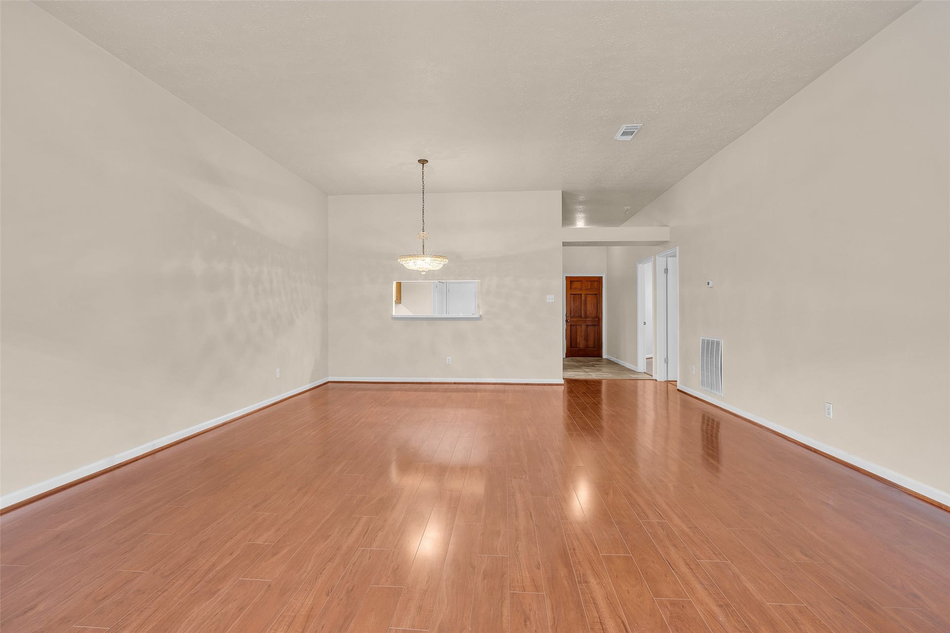 3310 Country Meadows Court, Pearland, TX 77584 View of both the living and dining areas in an open layout, with a glimpse of the main entrance, highlighting a connected and welcoming flow throughout the main living space.