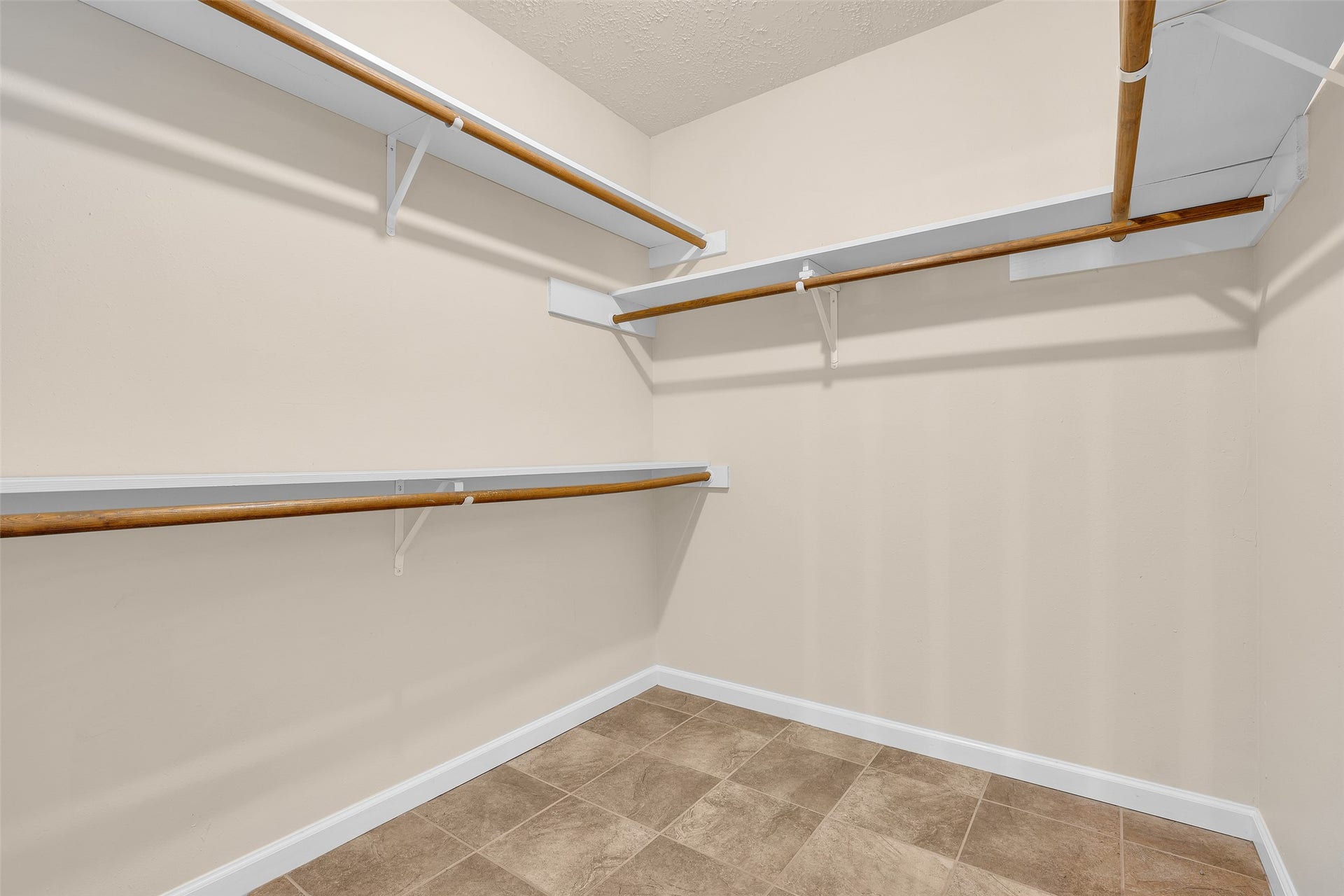 3310 Country Meadows Court, Pearland, TX 77584 Walk-in closet in the primary bedroom featuring built-in shelves and hanging rods, providing organized storage space for clothing, shoes, and accessories.