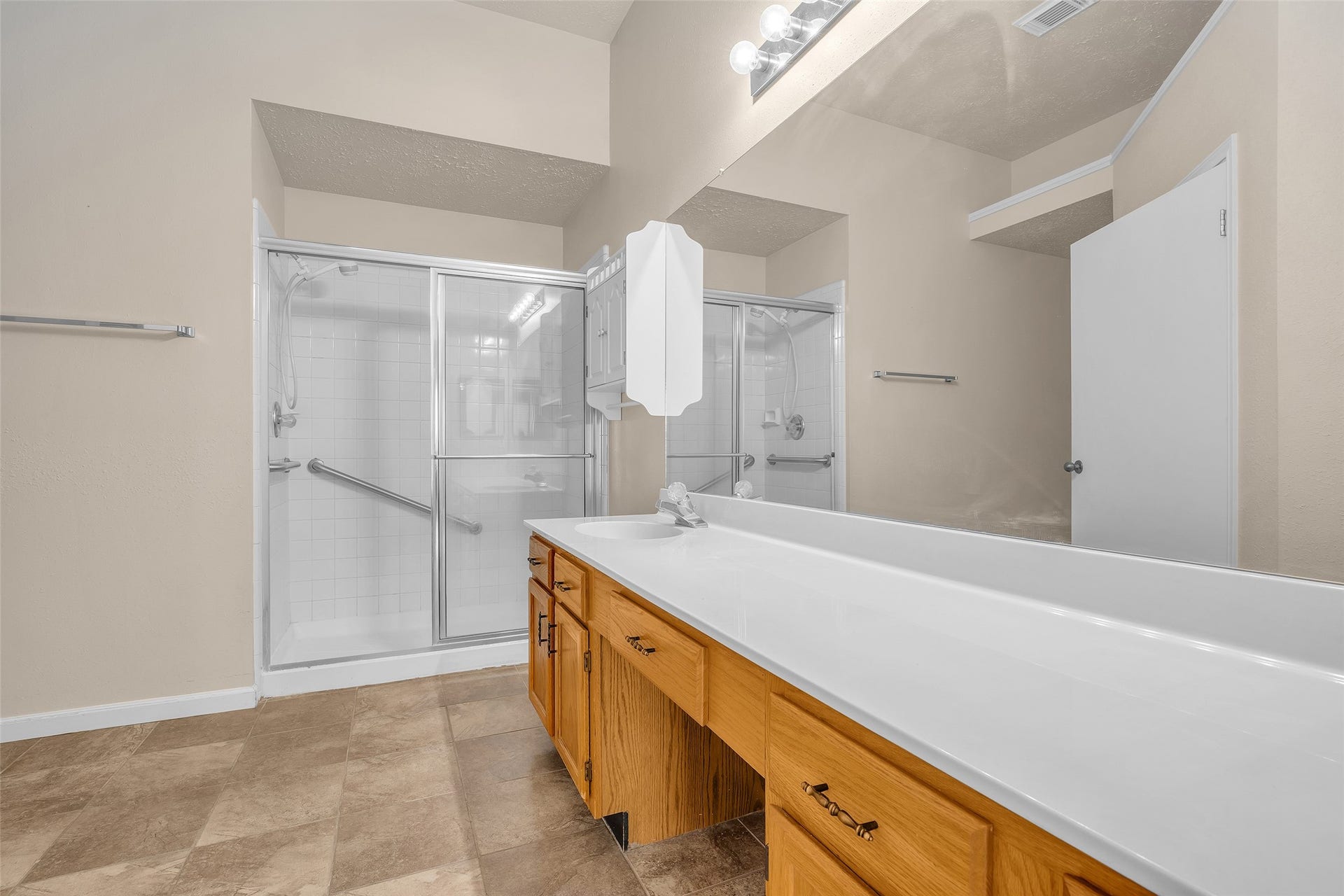 3310 Country Meadows Court, Pearland, TX 77584 Primary bathroom features ample counter space, a vanity area with laminate countertops, and an enclosed shower, offering a clean, functional layout designed for everyday use.