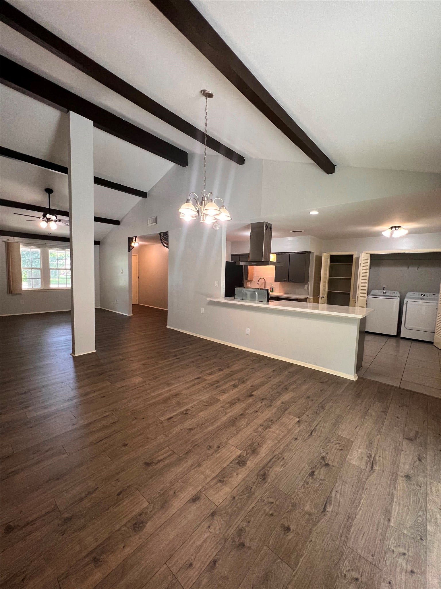 9543 Beverlyhill St, Houston, TX 77063 Open-concept living, dining, and kitchen area with soaring beamed ceilings and wood flooring.