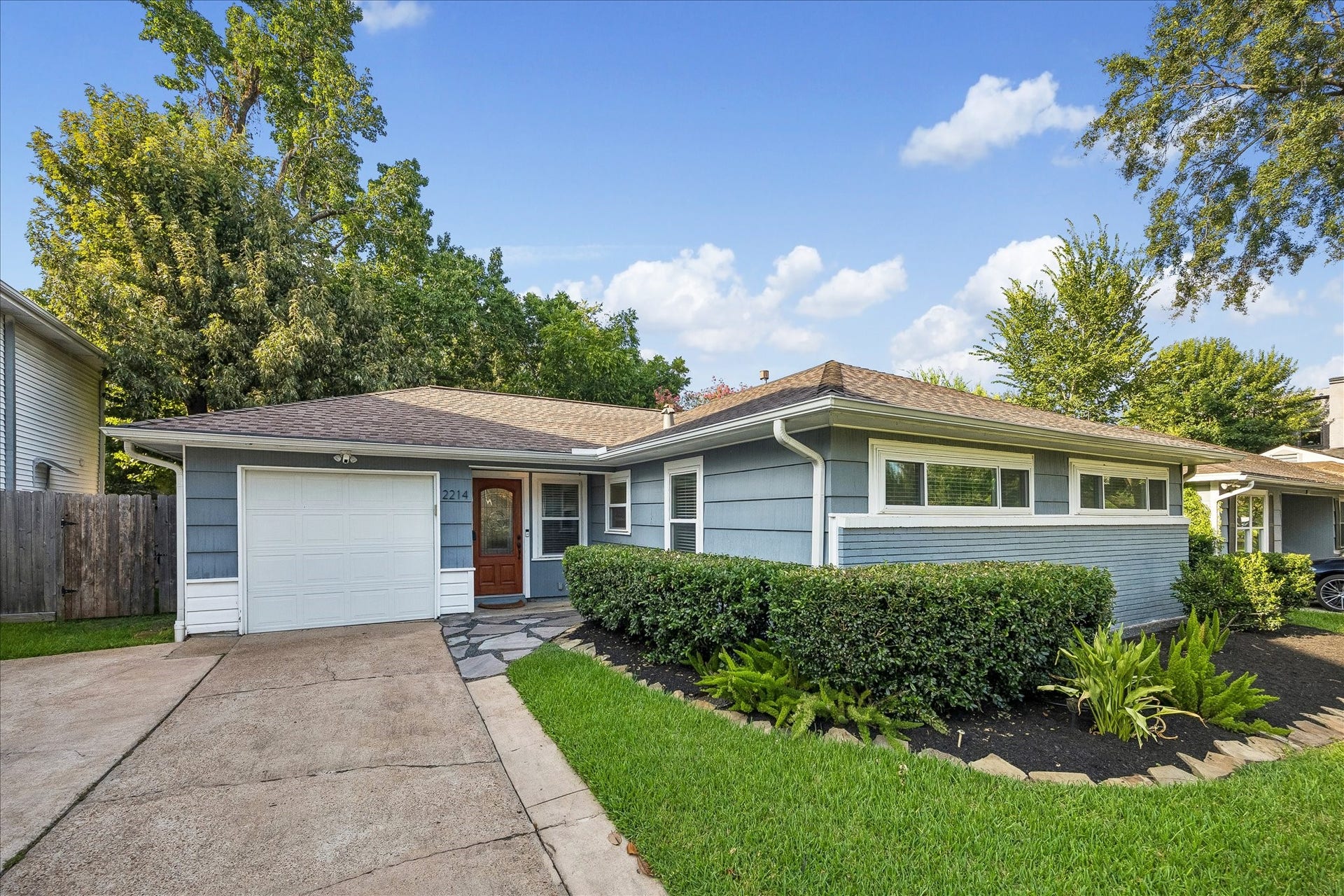 2214 Saxon Drive, Houston, TX 77018 Welcoming front entry is complemented by lush landscaping, a private driveway, and an attached garage. Thoughtfully maintained exterior offers classic style with a warm, approachable feel.