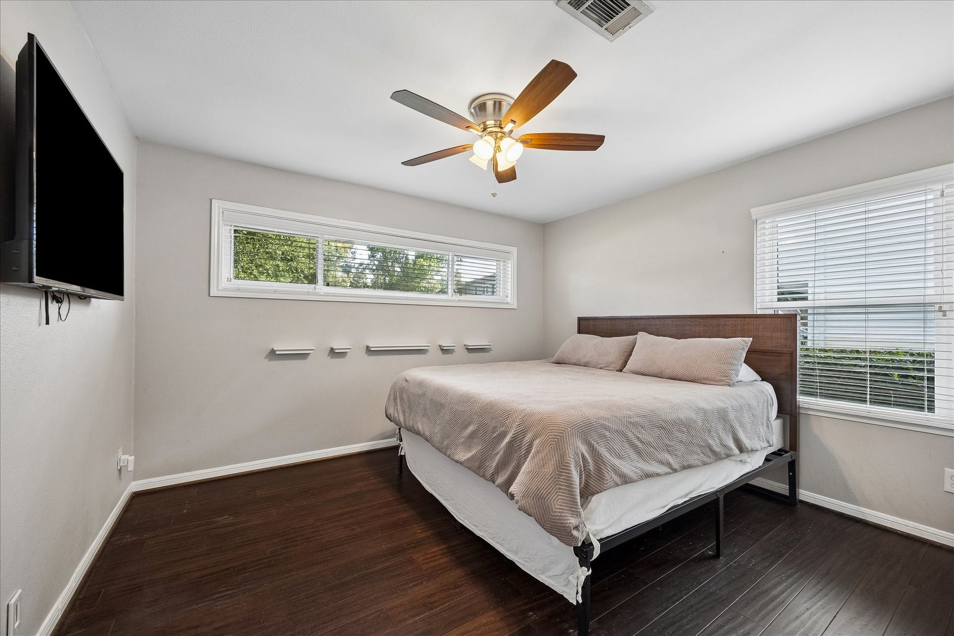 2214 Saxon Drive, Houston, TX 77018 Oversized windows fill this secondary bedroom with natural light, creating a bright and inviting retreat for family or guests. Clean lines, warm flooring, and a flexible layout make the space equally suited for a bedroom, nursery, or home office.